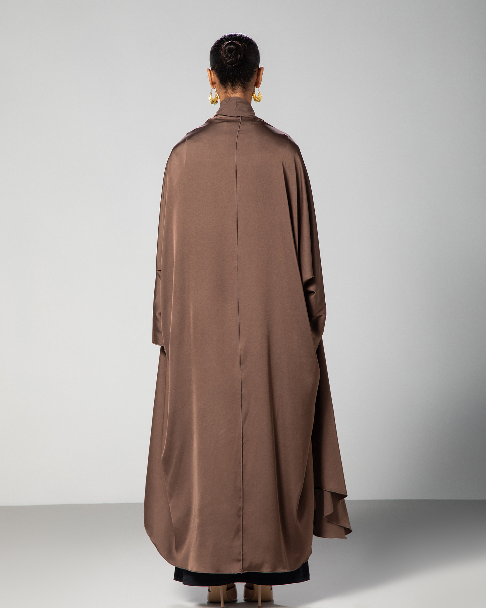 Back view of the brown Flow Abaya by Omni The Label, showcasing the abaya’s full length, wide sleeves, and clean tailoring KSA UAE Qatar