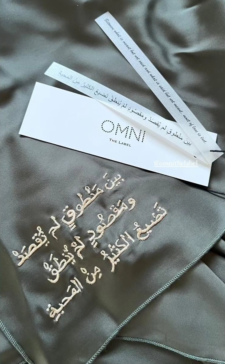 Detailed embroidery shot from Omni The Label’s Flow Abaya featuring Arabic text – UAE, KSA, Qatar