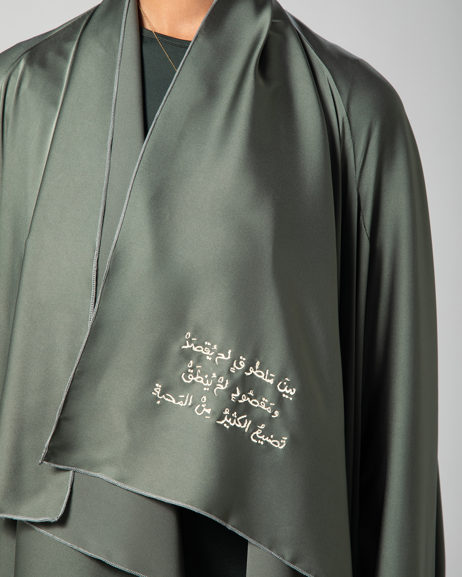 Close-up of Arabic calligraphy on Omni The Label’s Flow Abaya in sage green – UAE, KSA, Qatar