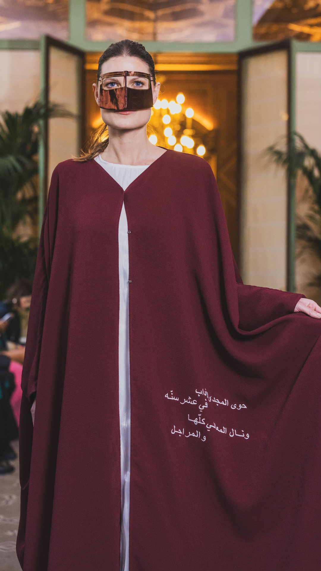 Model in burgundy abaya with arms extended showing full silhouette and flow – UAE, KSA, Qatar