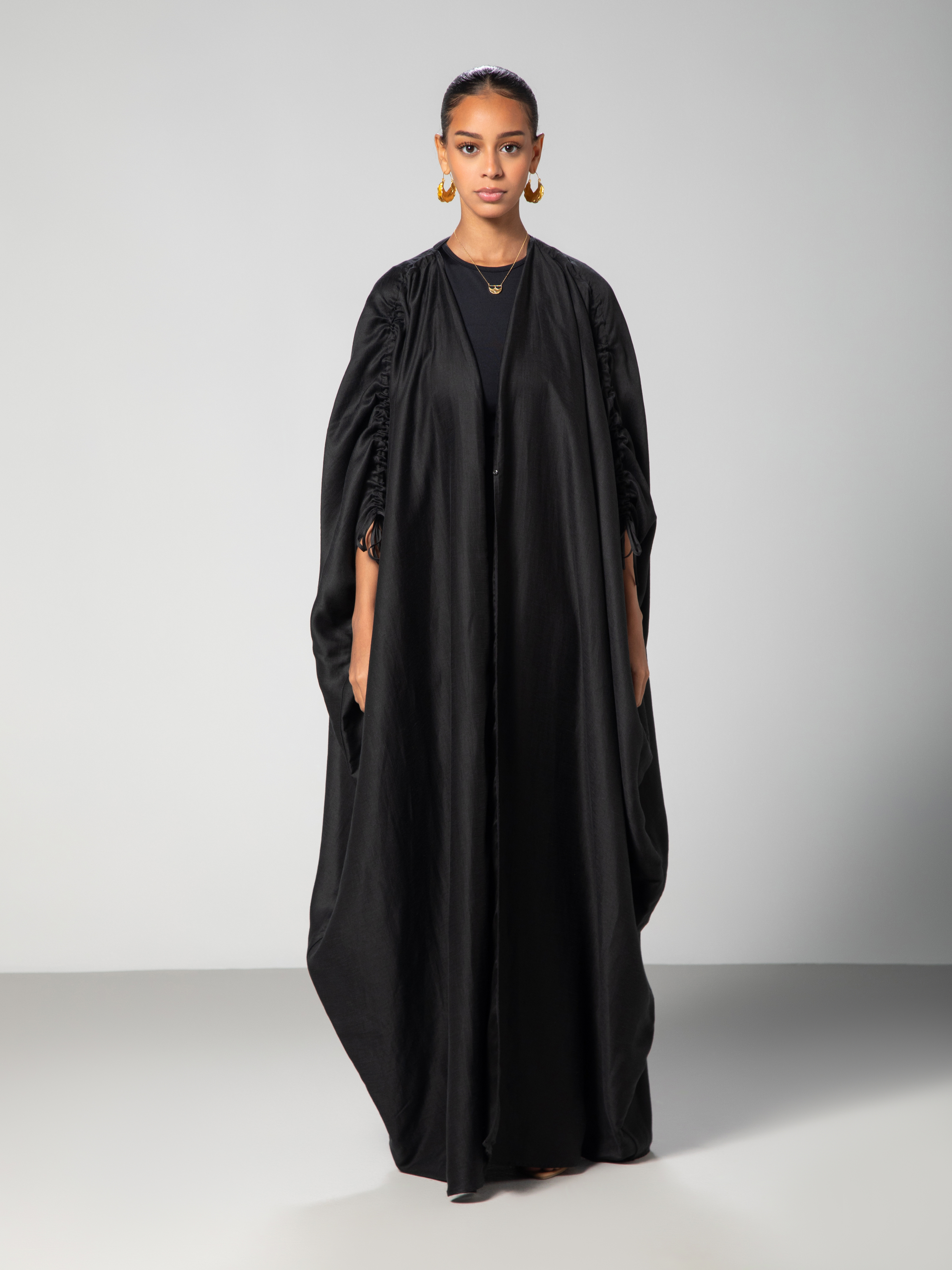Full lenghtBlack abaya with adjustable sleeves Arabic calligraphy embroidery on the back studio Omni The Label UAE KSA Qatar