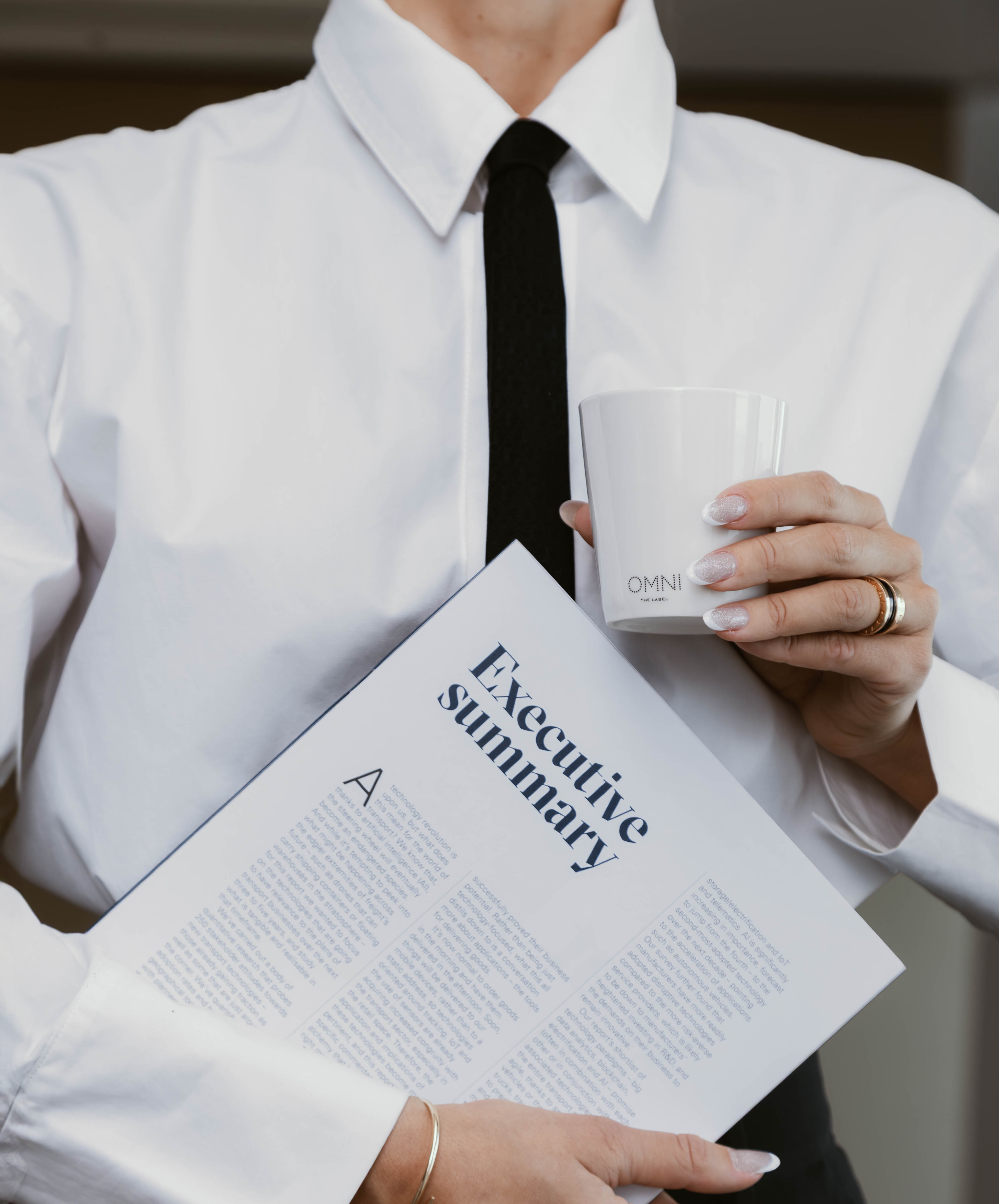 Person holding a document titled 'Executive Summary' and a cup.