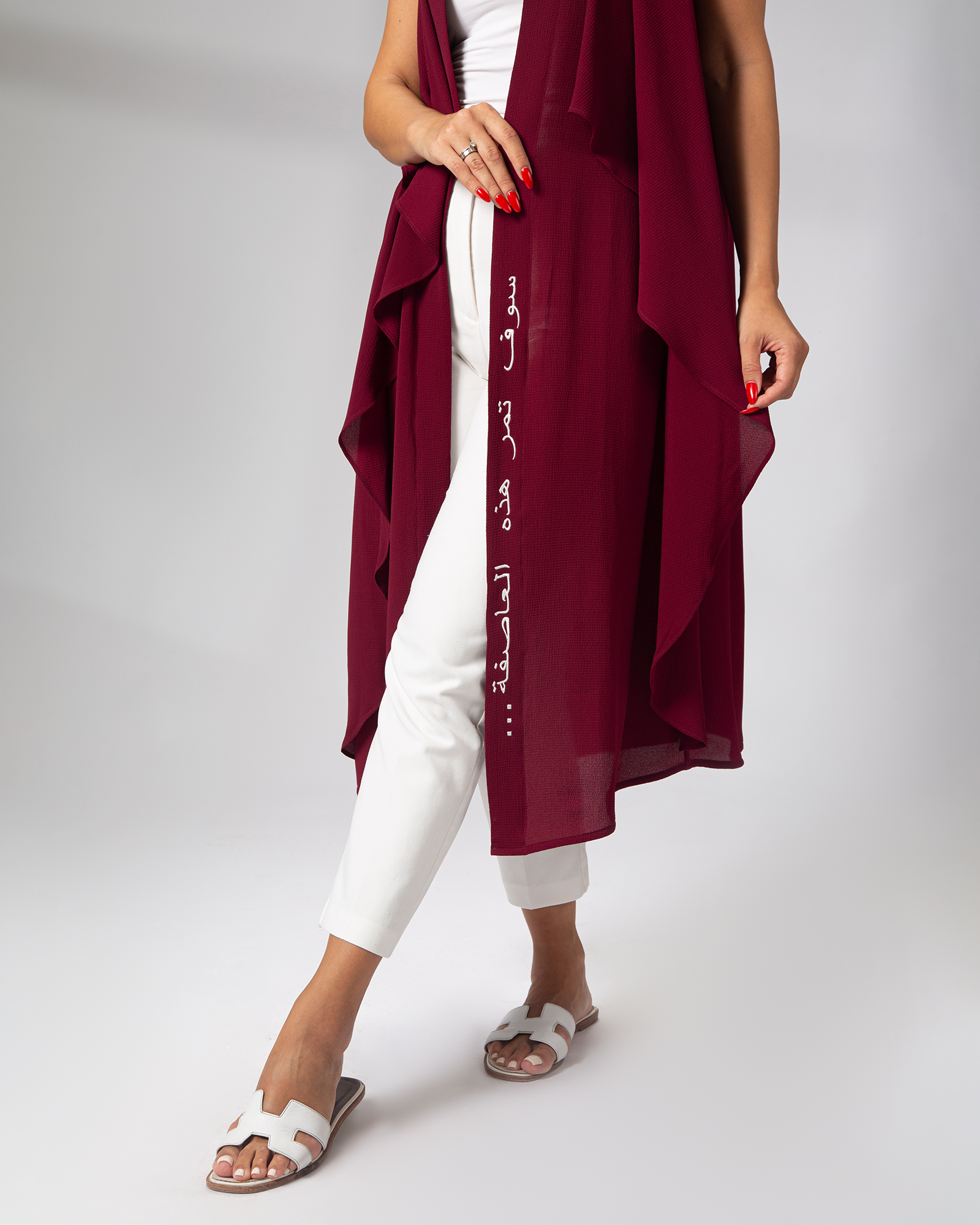 Detailed close up of Arabic embroidery on burgundy cover up by Omni The Label refined styling appreciated in Qatar UAE KSA