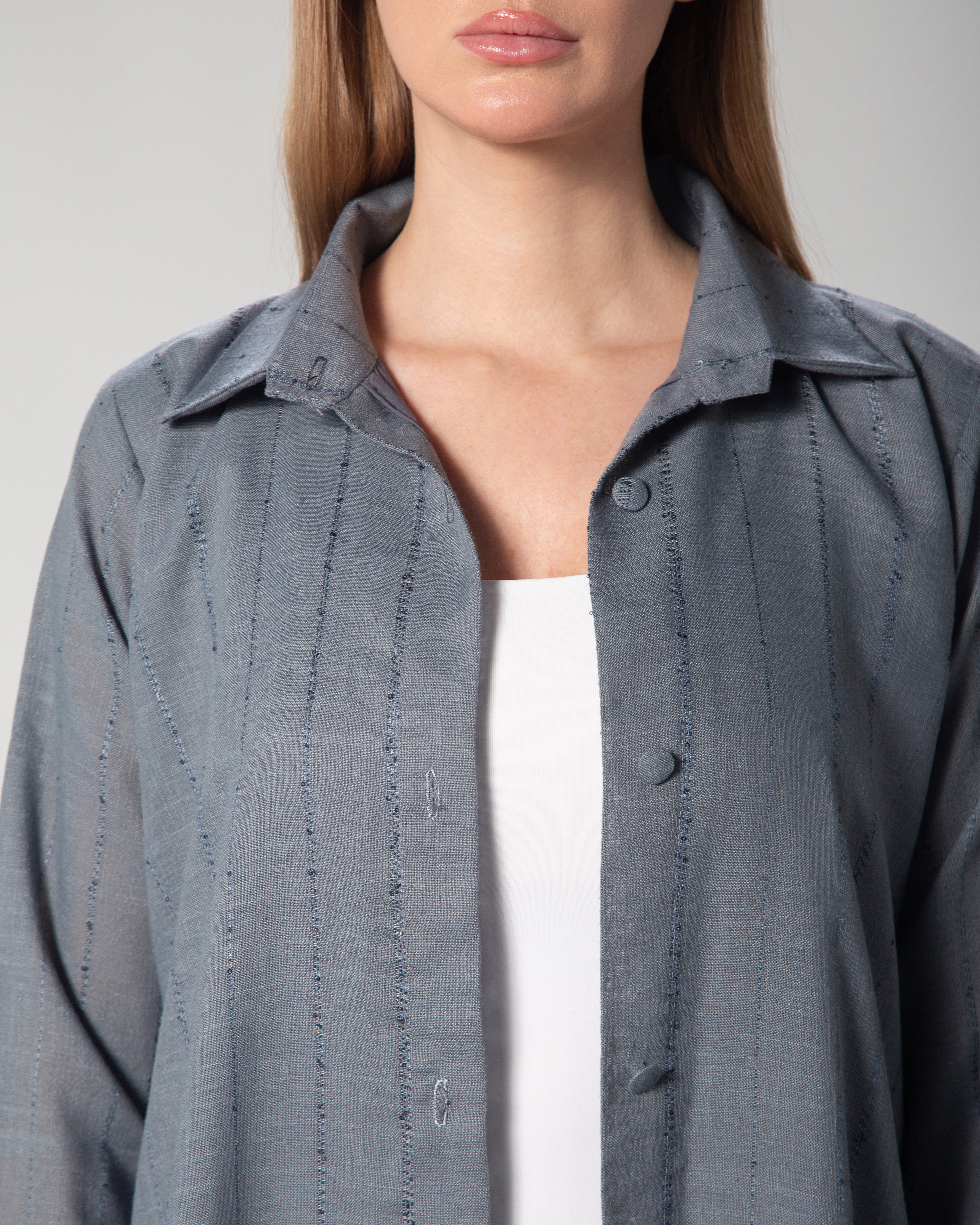 A woman wearing a blue linen collared abaya with sequins, featuring a A-line cut and fabric-covered buttons middle east saudi kuwait qatar modest fashion
