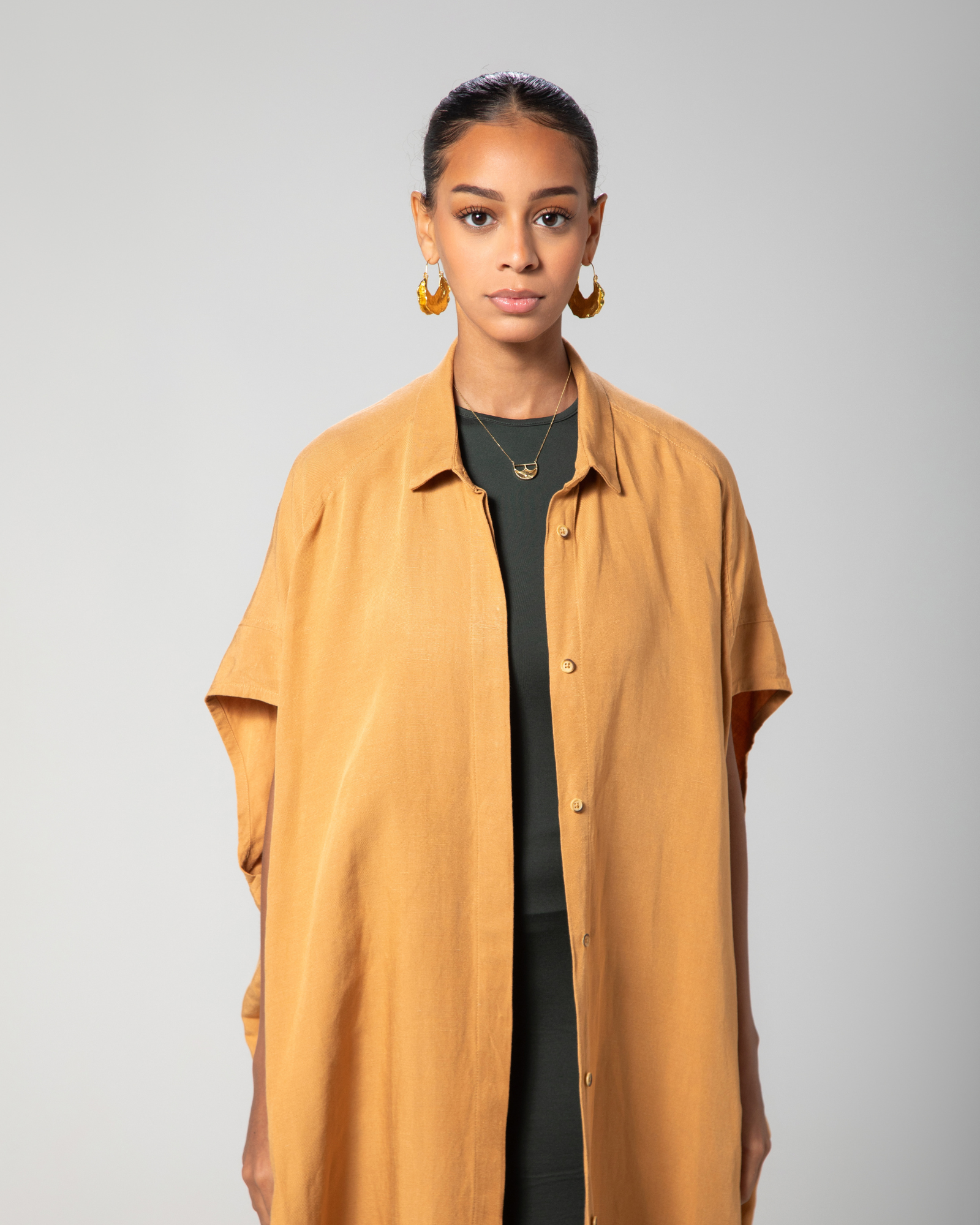Close-up showing collar and front detail of camel brown kaftan by Omni The Label Qatar UAE KSA