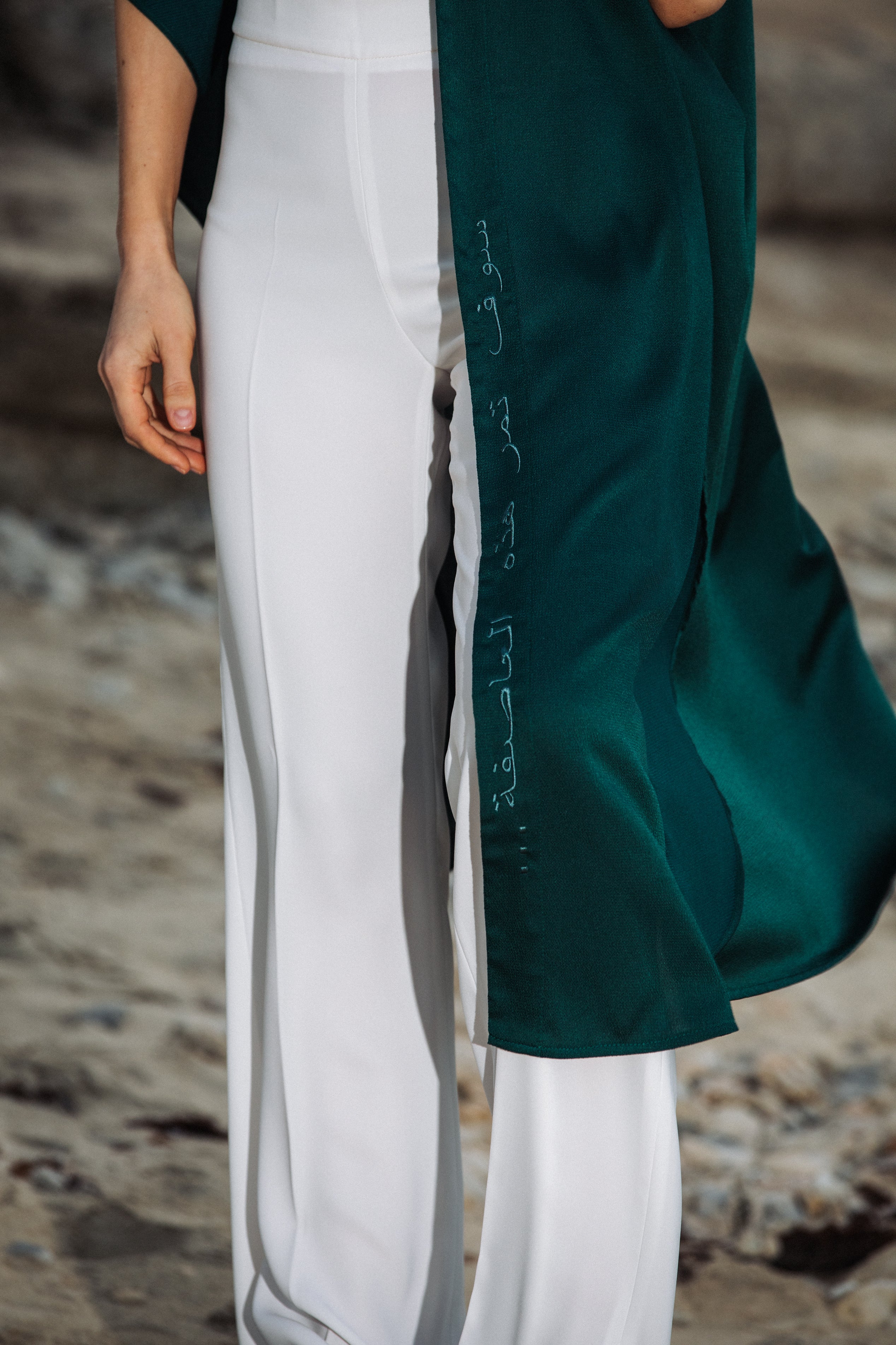 Detailed shot of green fabric and Arabic quote print on sleeveless cover-up – UAE, KSA, Qatar