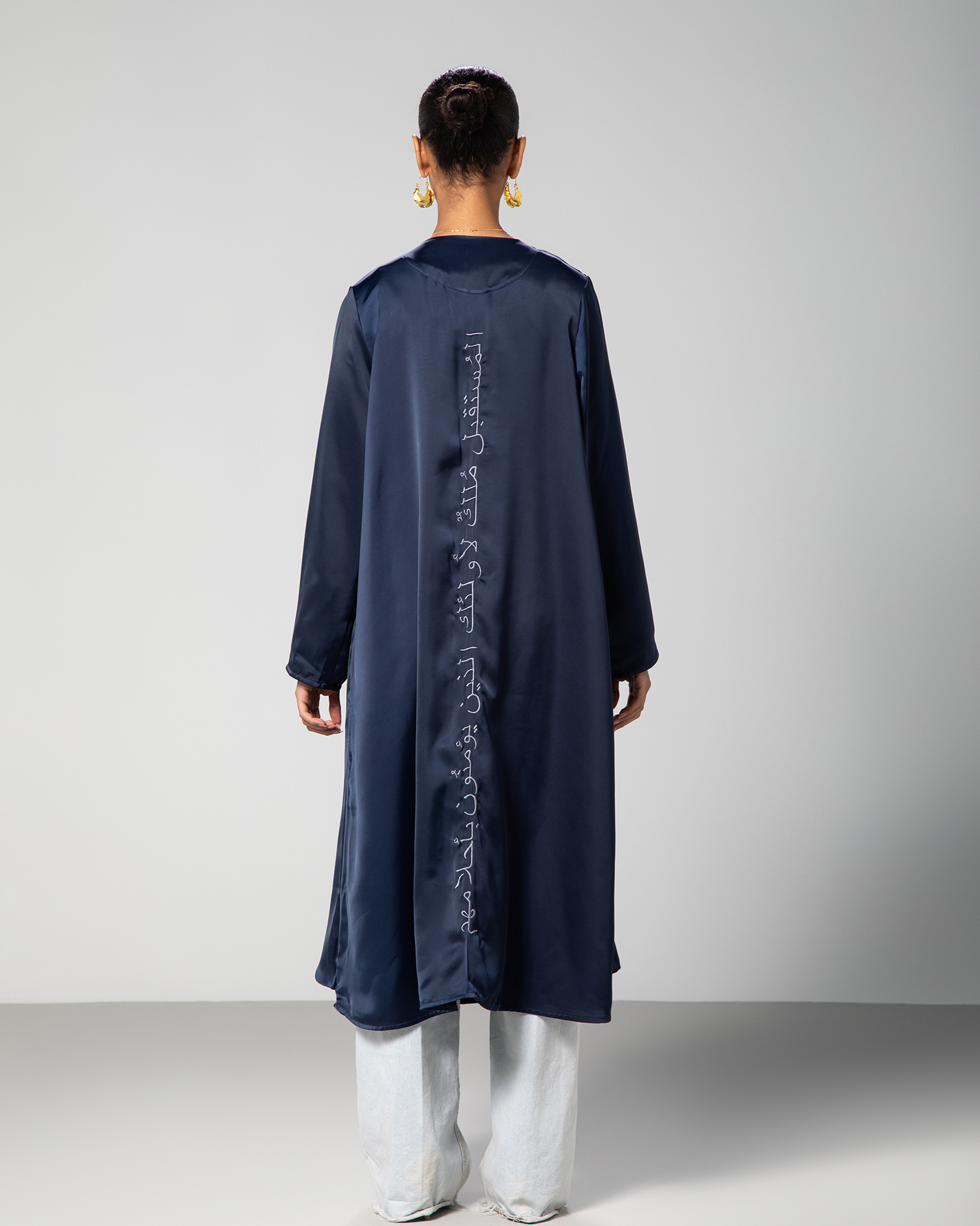Back view of navy blue cover-up by Omni The Label, featuring Arabic calligraphy embroidery that reads: “The future belongs to those who believe in their dreams.” KSA UAE Qatar