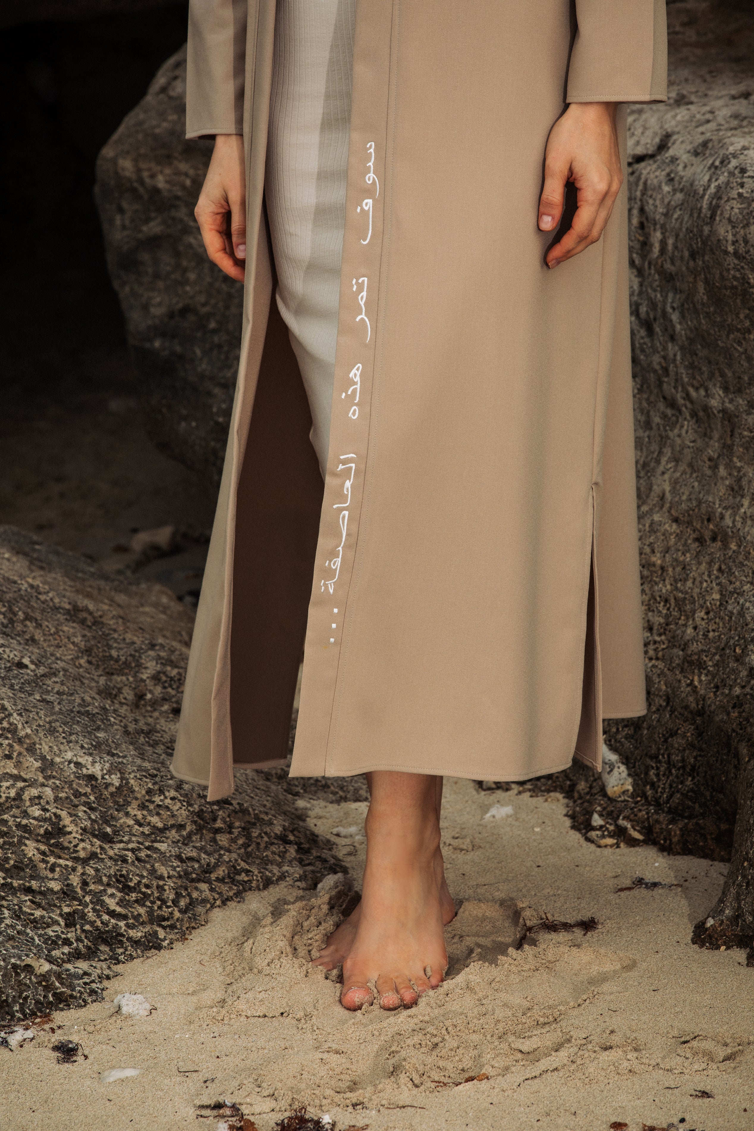 Close-up of Arabic embroidery reading "This too shall pass..." on nude kimono, delicate stitching on soft viscose fabric – Omni The Label uae ksa qatar