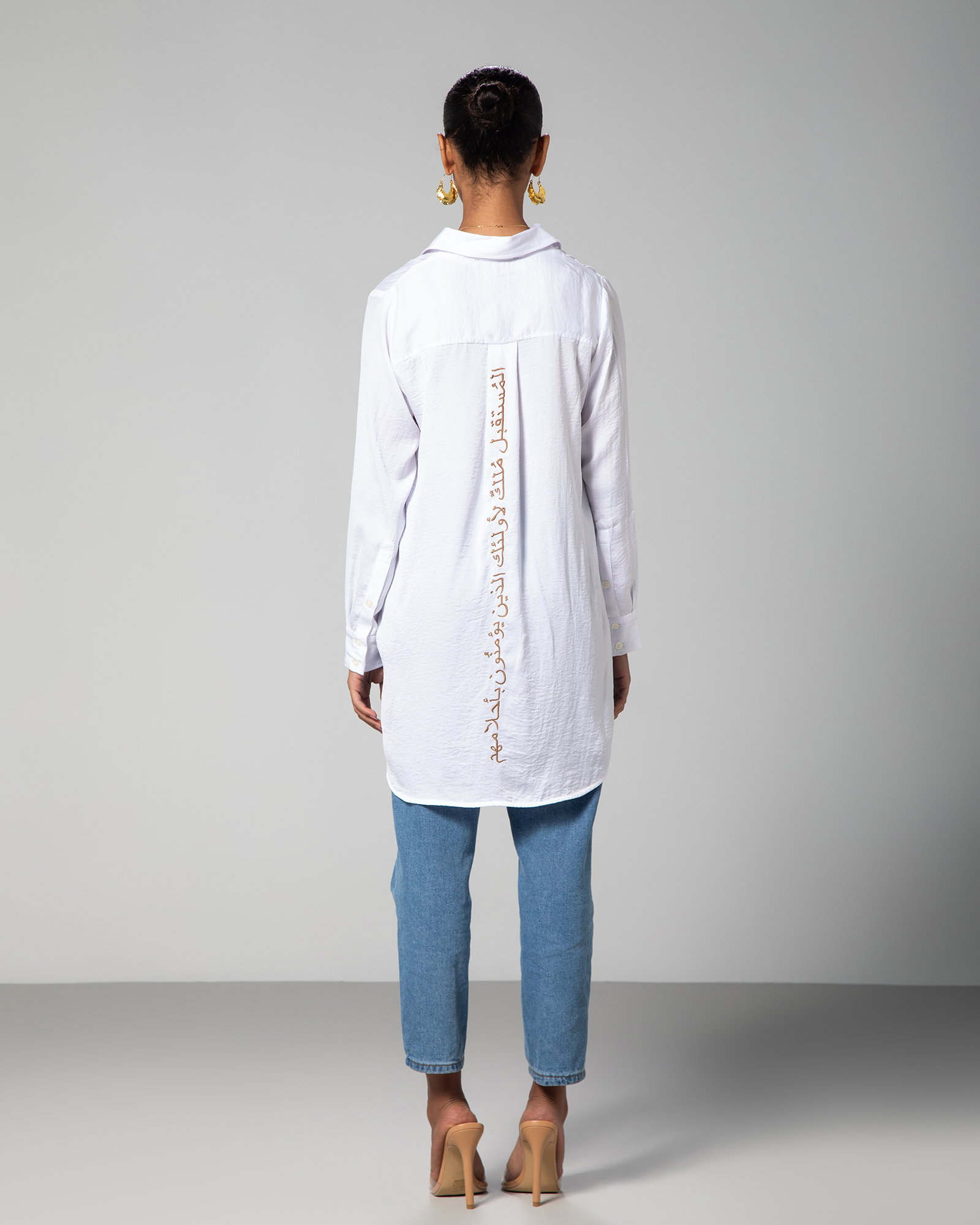 Back view of white collared shirt by Omni The Label with Arabic embroidery reading "The future belongs to those who believe in their dreams" popular style in UAE KSA Qatar