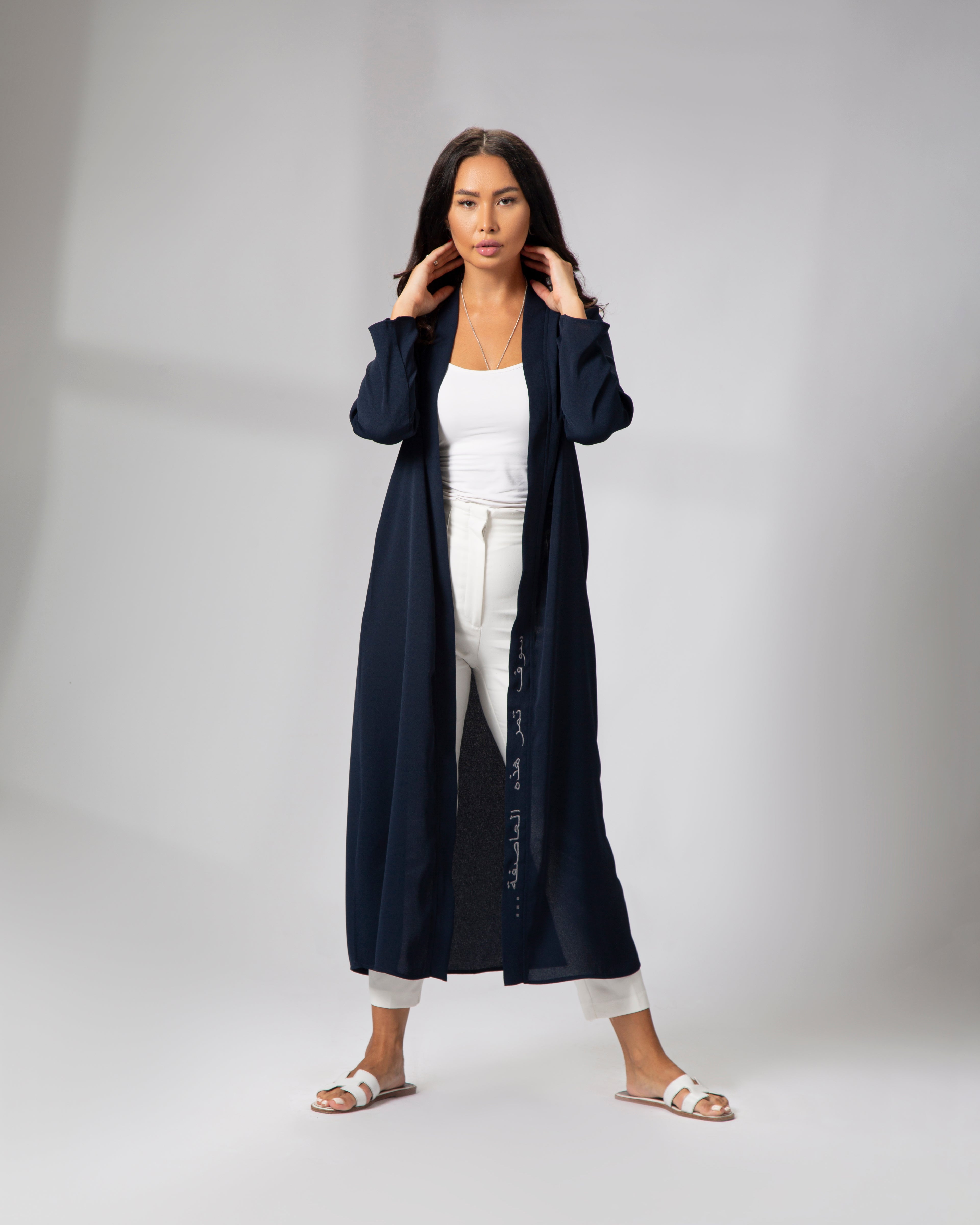 Full-length front view of a woman wearing the navy kimono, styled open with white outfit underneath KSA UAE Qatar
