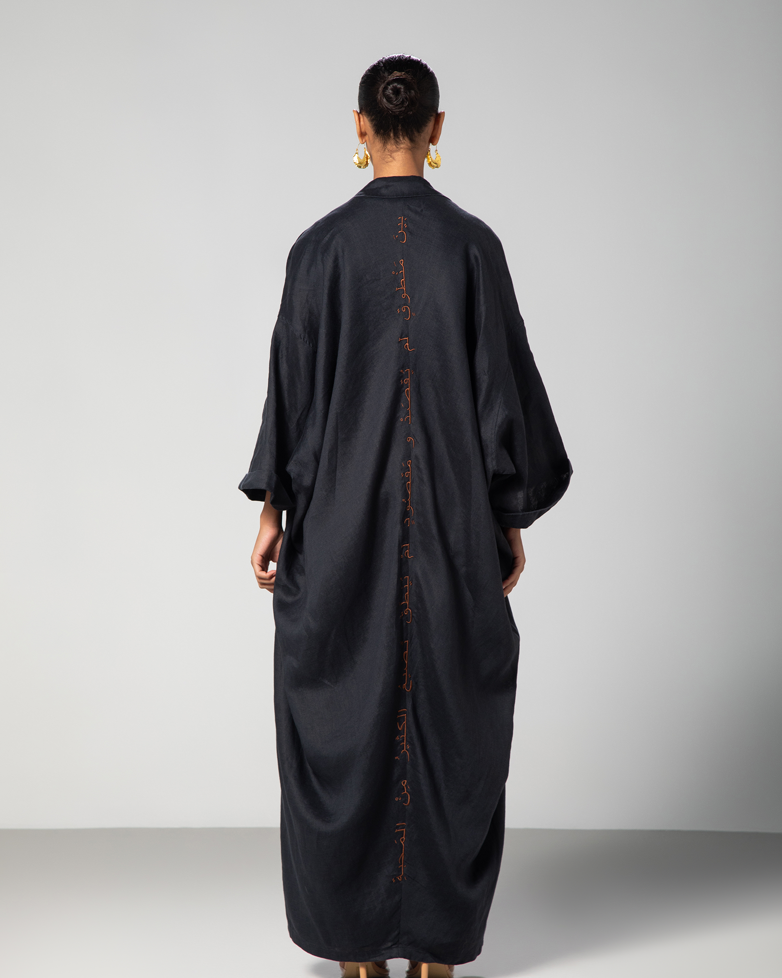 woman wearing kaftan lifestyle shoot, backside of the kaftan with Arabic calligraphy.