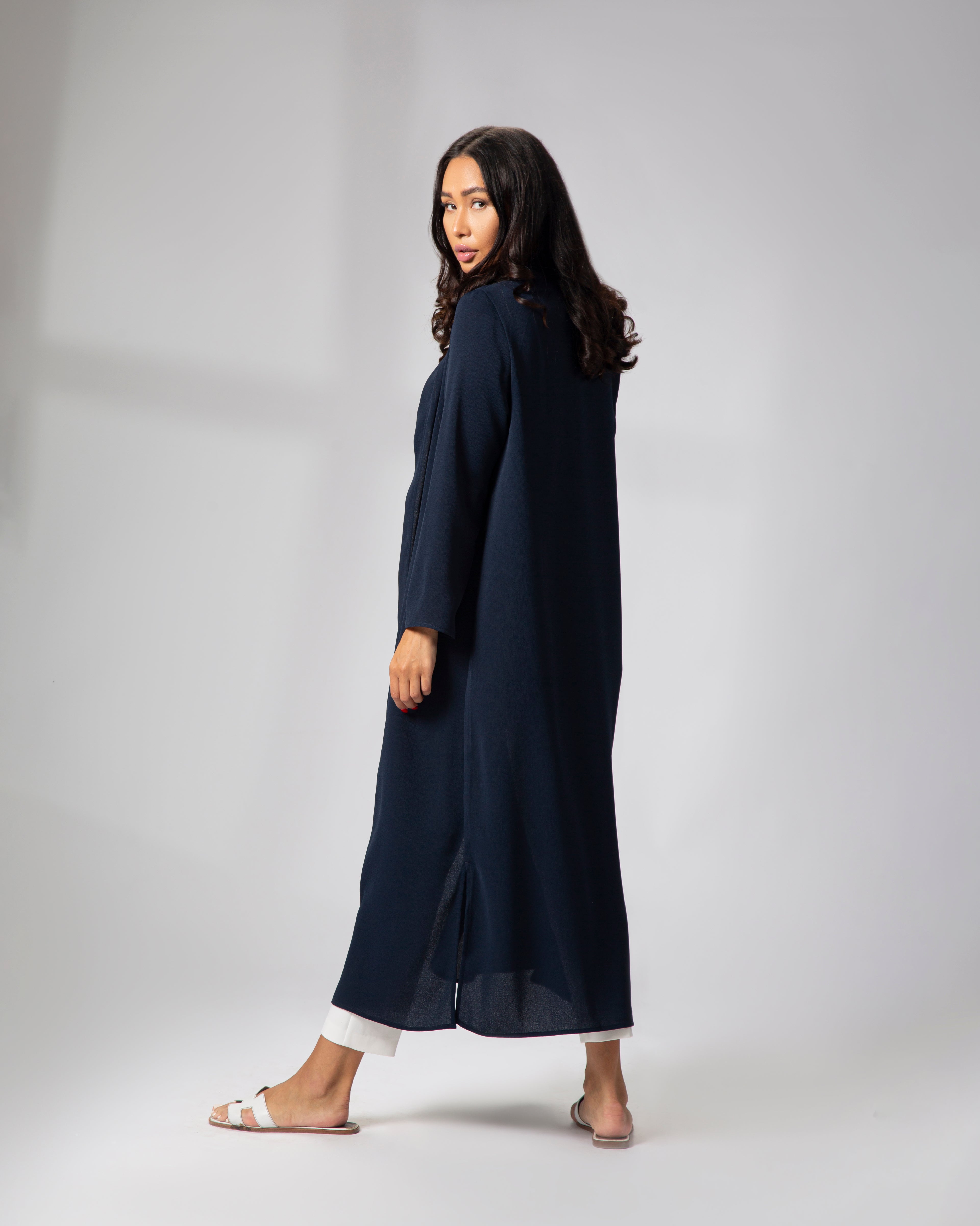 Side view of model wearing Omni The Label’s navy blue kimono, showcasing the open front and lightweight drape over a white ensemble KSA UAE Qatar
