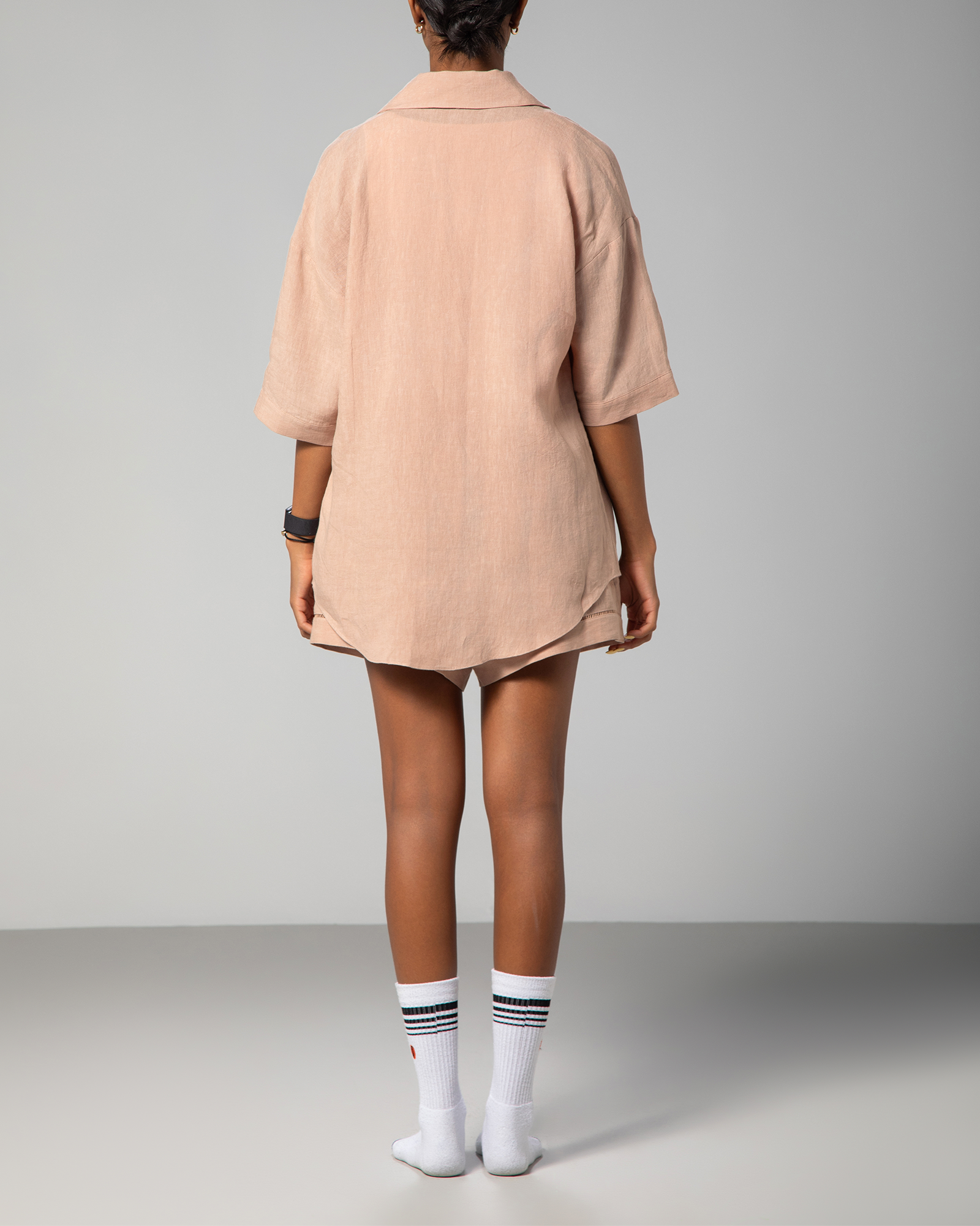 Back view of nude linen shirt and shorts set from Omni The Label, highlighting the loose fit and subtle detailing of the fabric UAE KSA Qatar