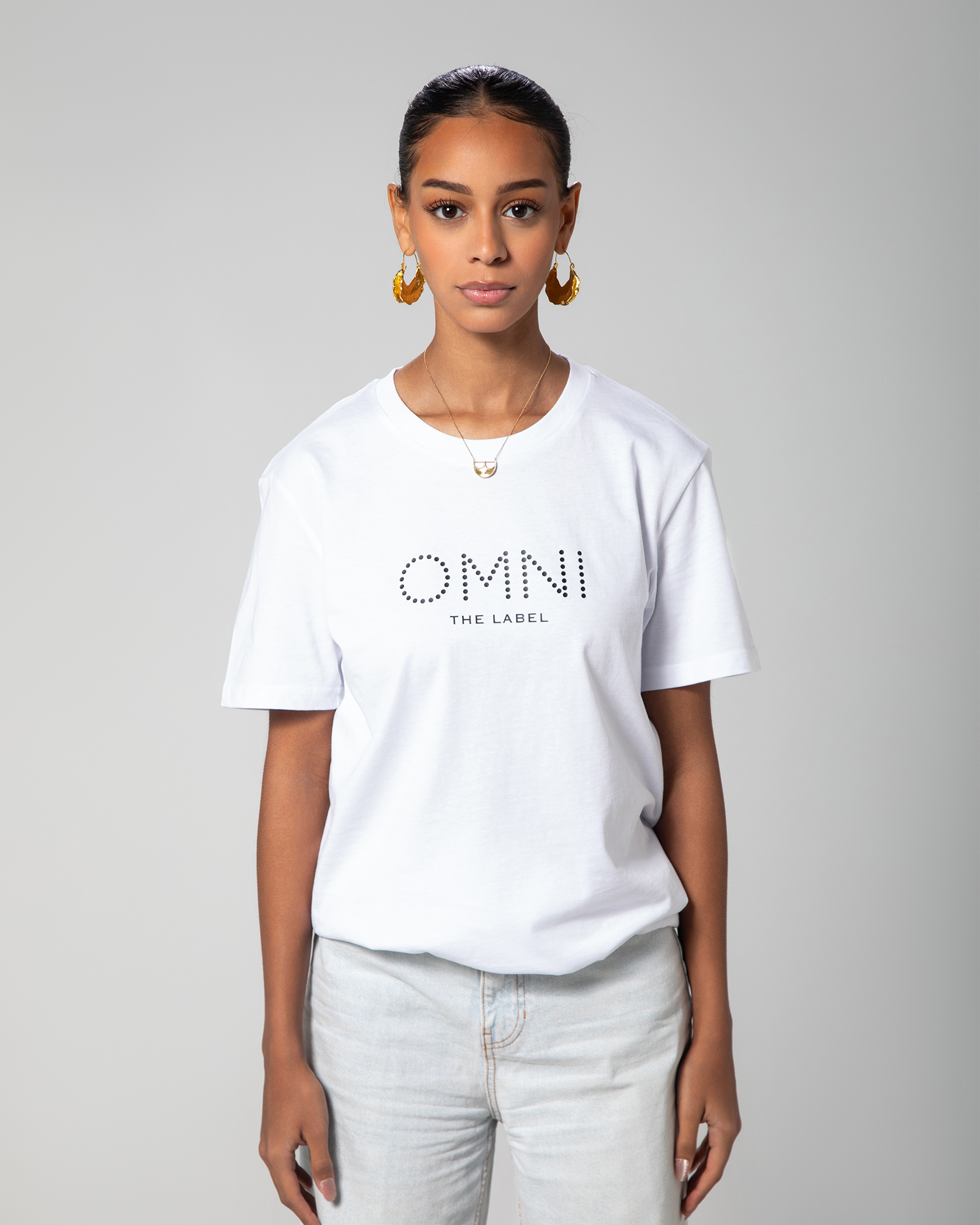 Front view of model wearing minimalist white T-shirt from Omni The Label with subtle branding—perfect for casual wear KSA UAE Qatar