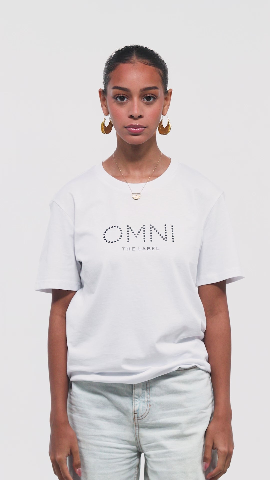Video of white T-shirt by Omni The Label featuring Arabic calligraphy print on the back—modern Middle Eastern streetwear designed for Qatar, UAE, KSA.