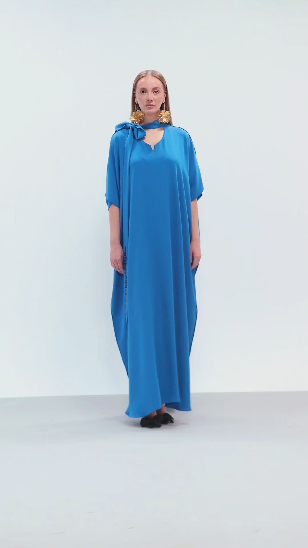 Model walking in royal blue embroidered maxi dress with tie neckline for Omni The Label campaign targeting luxury modest fashion in UAE Qatar KSA