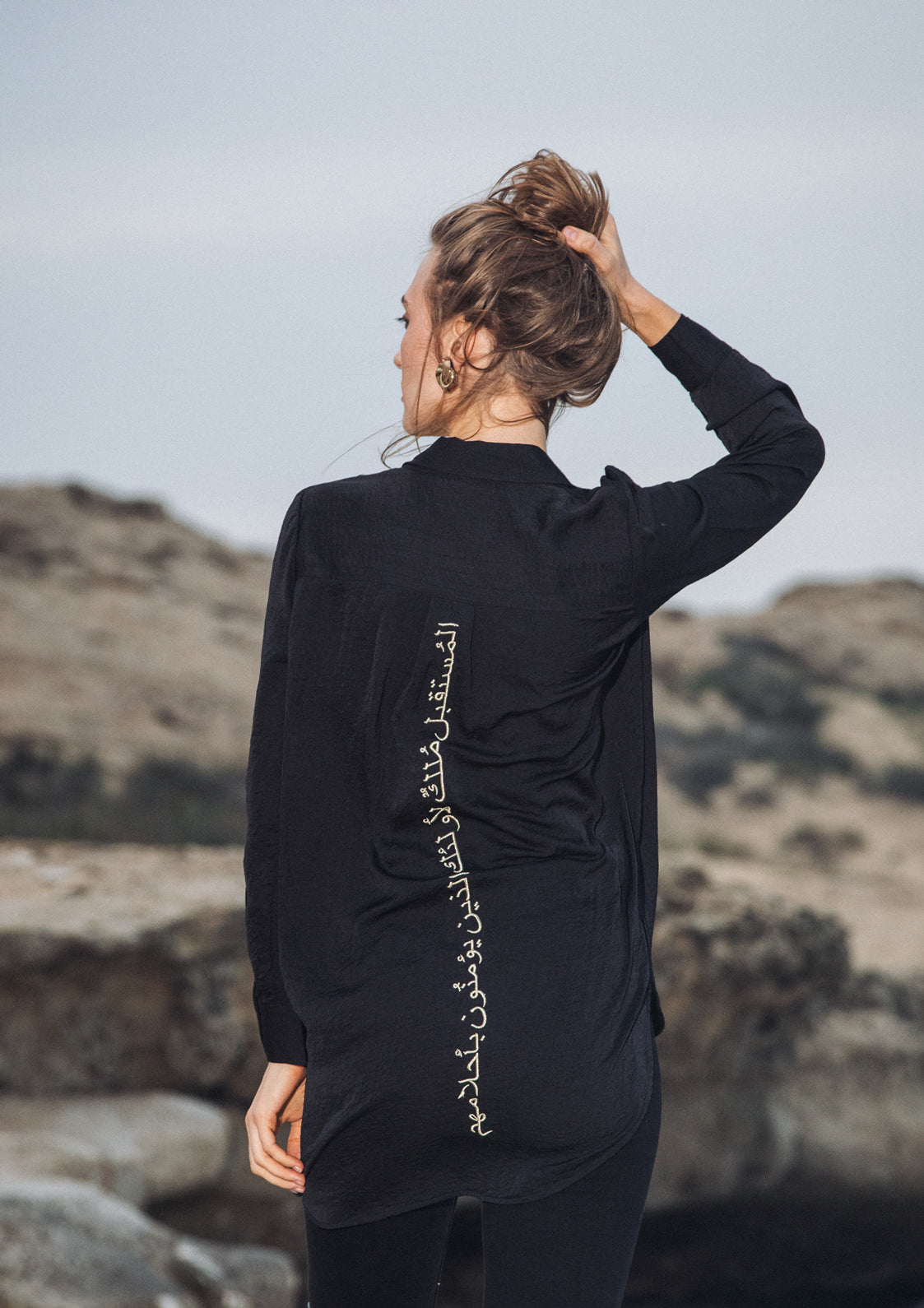 Gold-thread Arabic embroidery on the back of Omni The Label’s black shirt – UAE, KSA, Qatar