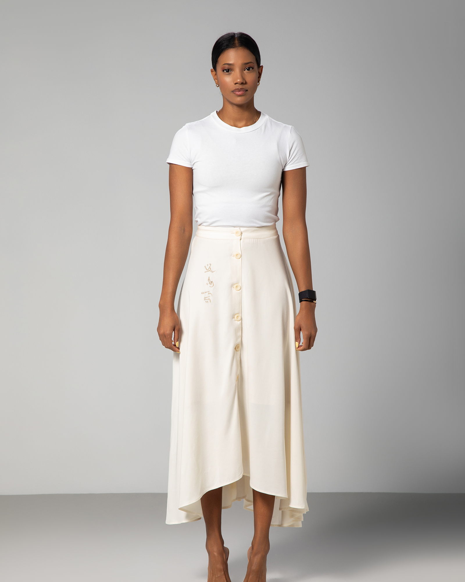 Model wearing The Next Wednesday Skirt in off-white with Arabic embroidery, styled with white top – UAE, KSA, Qatar