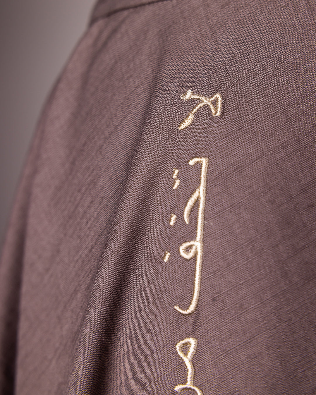 Close-up of Arabic calligraphy embroidery on The Next Wednesday Skirt by Omni The Label in brown – statement fashion piece UAE KSA Qatar
