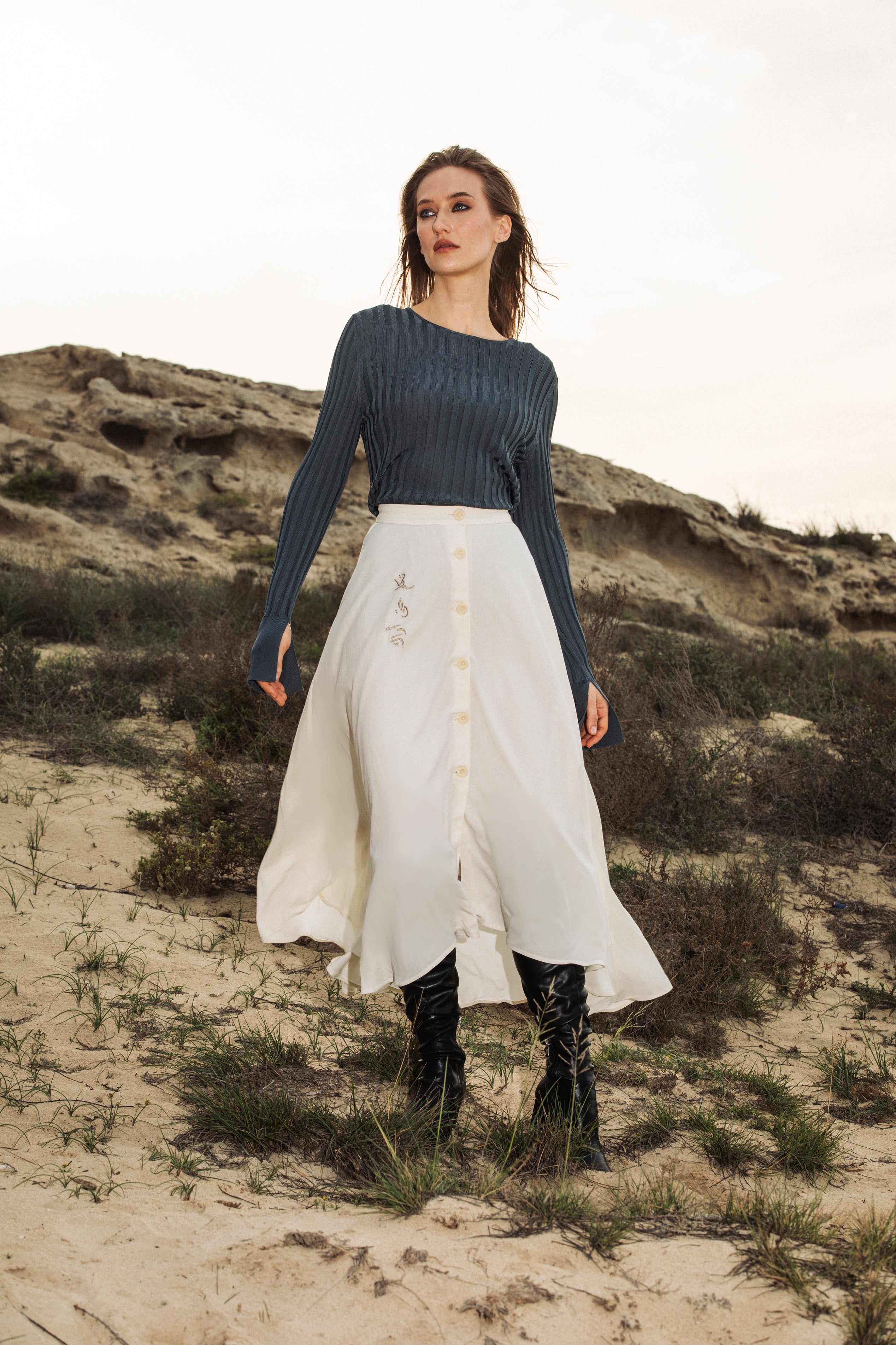 Model standing in desert wearing The Next Wednesday Skirt styled casually – UAE, KSA, Qatar