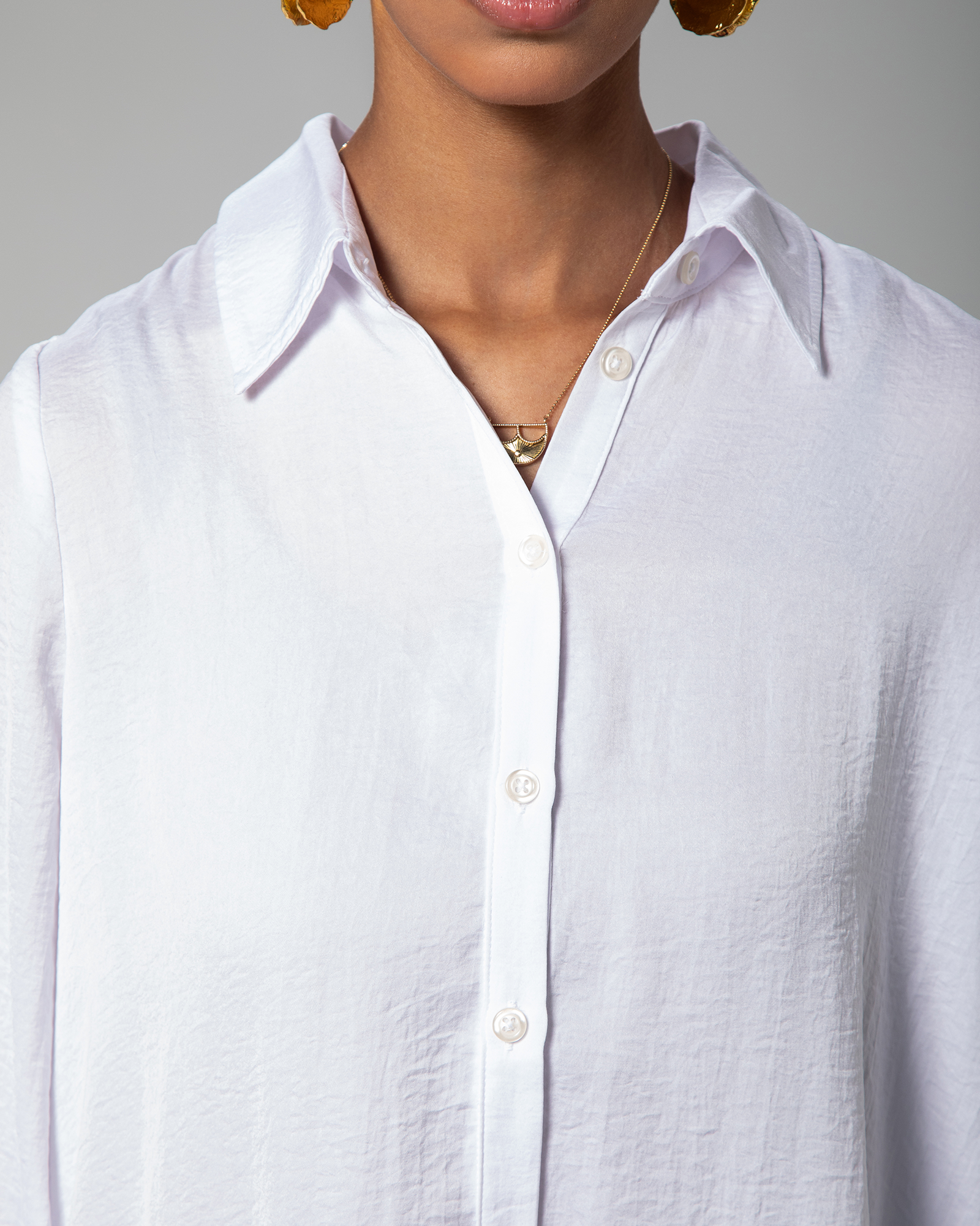 Close-up of collar and button detailing on white Omni The Label shirt premium  fashion UAE KSA Qatar