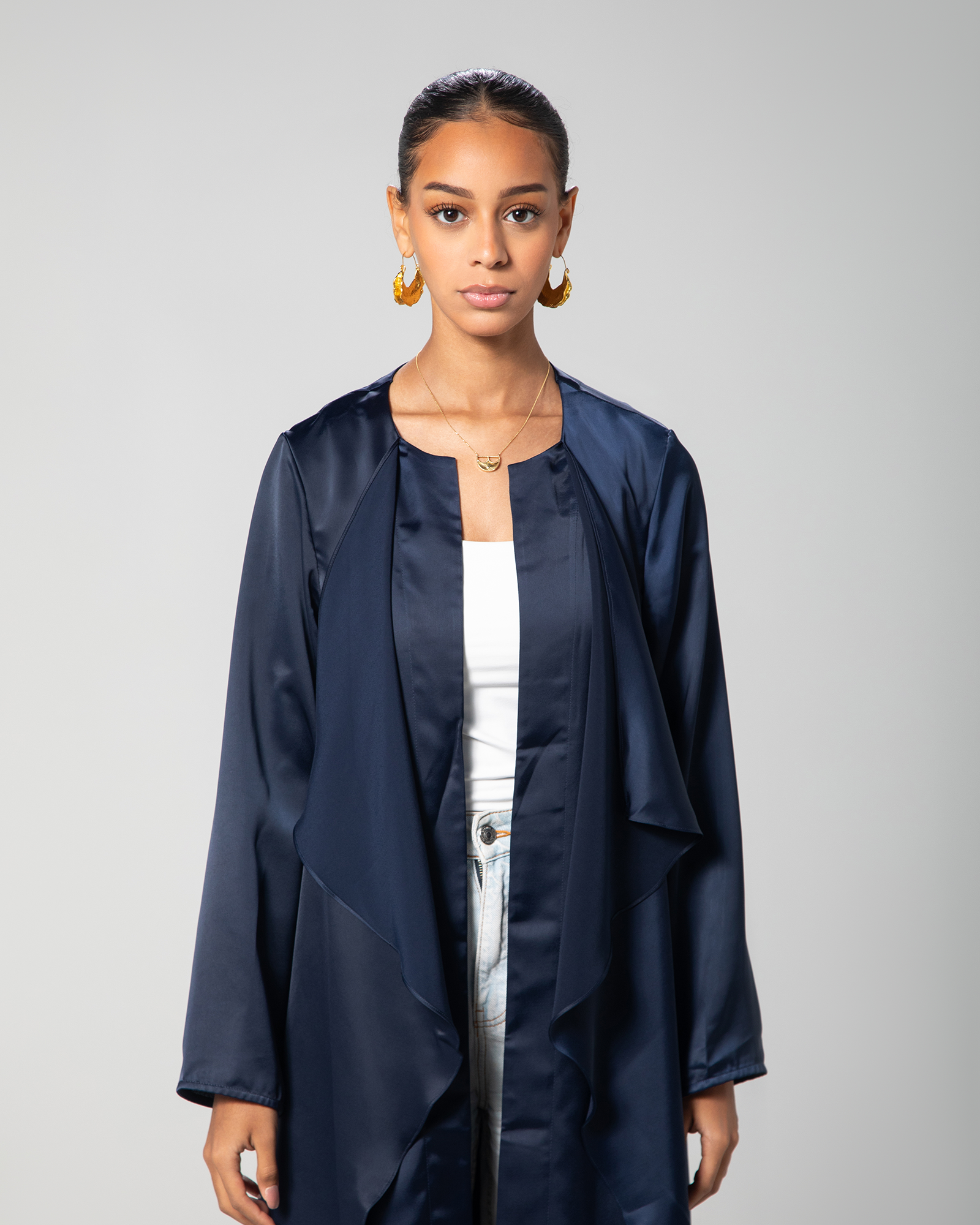 Mid-length image of model in navy blue cover-up worn open over a white tank top, showcasing versatility in styling KSA UAE Qatar