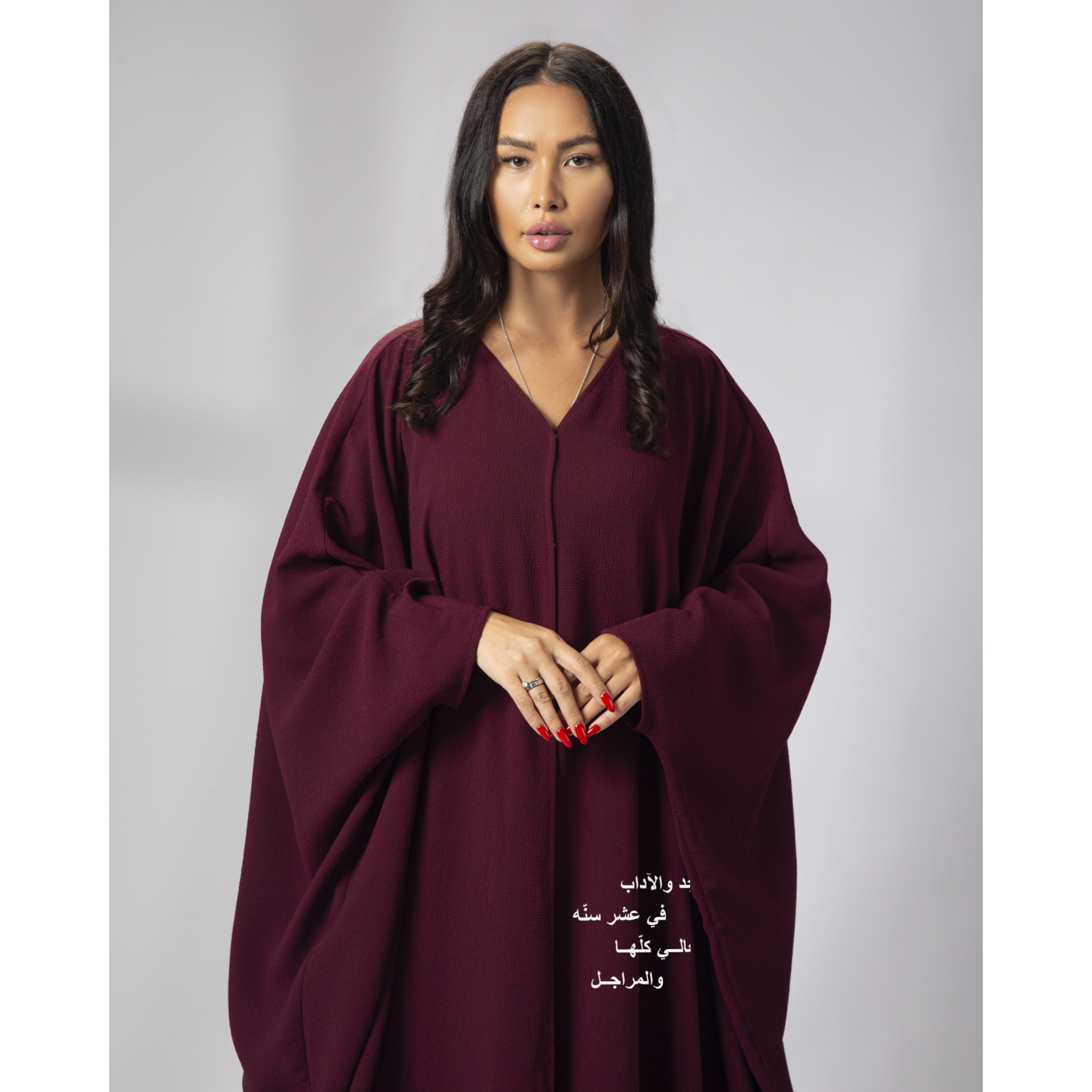 Burgundy National Day Abaya shown in studio with relaxed pose and elegant drape – UAE, KSA, Qatar