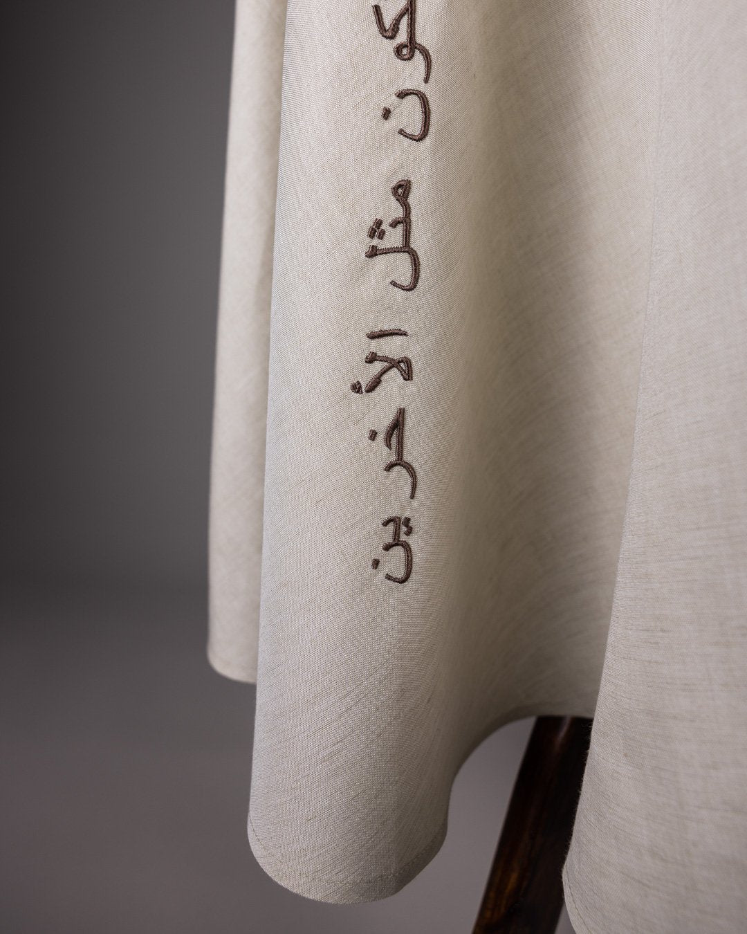 Zoomed-in Arabic calligraphy print on brown skirt by Omni The Label, fashion-forward design from the Gulf region