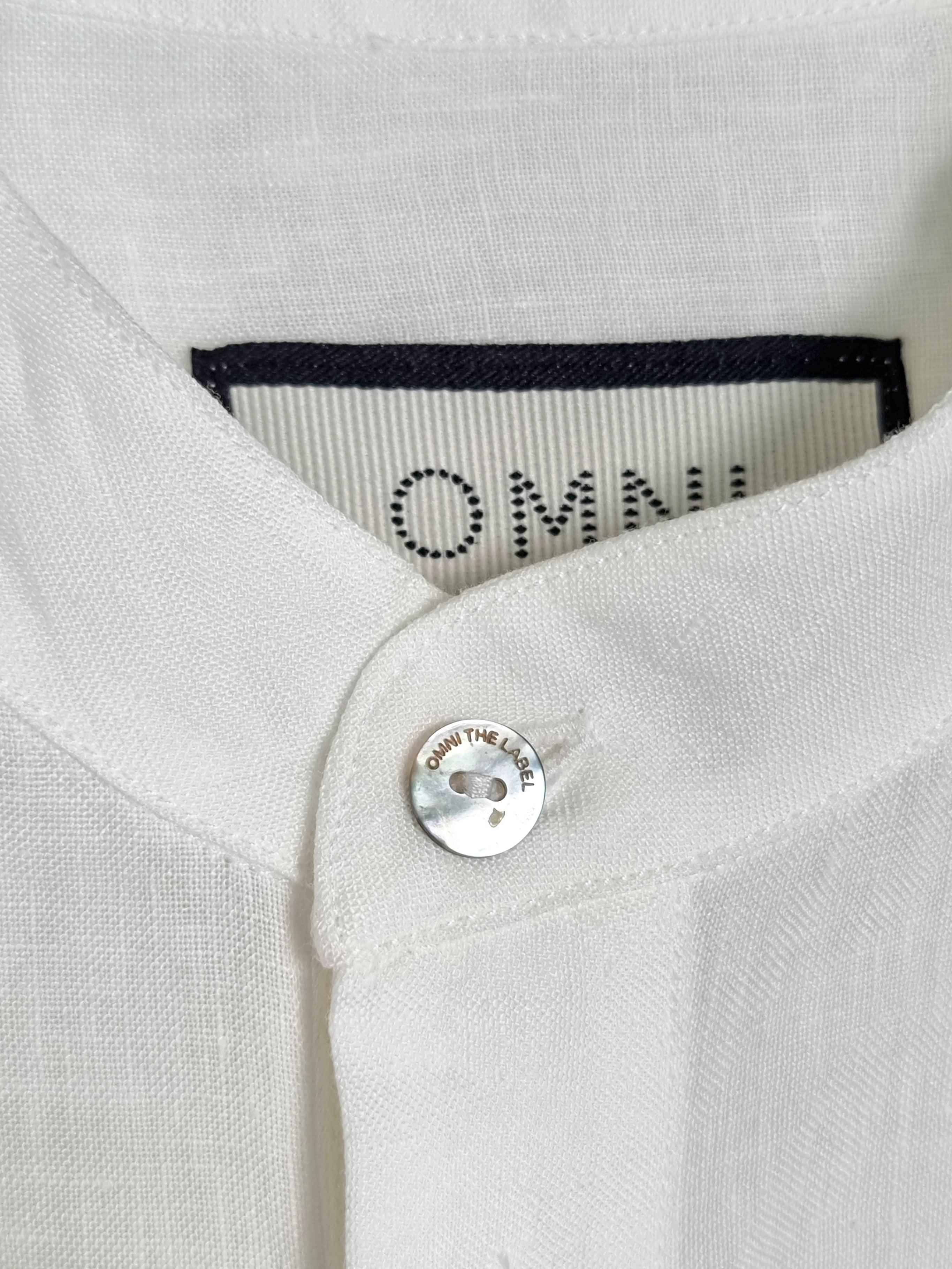 Detailed collar close-up with Omni The Label branding on the white St. Tropez Linen Shirt – UAE, KSA, Qatar