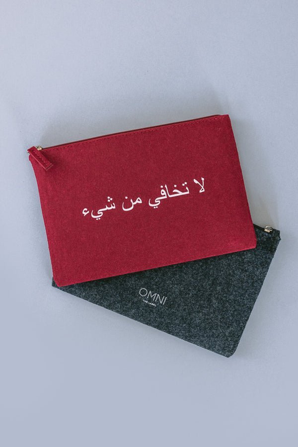 Two felt pouches, one grey and one red, with 'Omni' and an Arabic quote UAE KSA Qatar