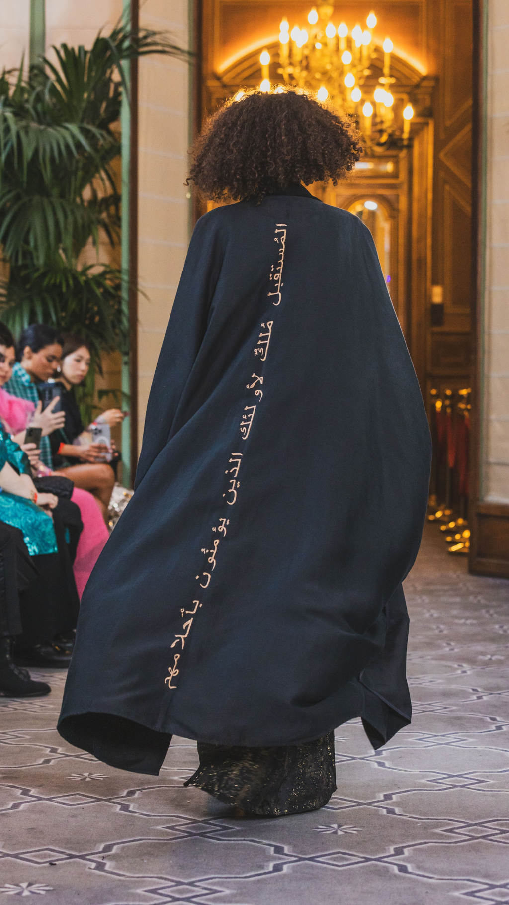 runaway from paris fashion week of abayas, a black abaya   with arabic caligraphy embroidered on the back by omni the label