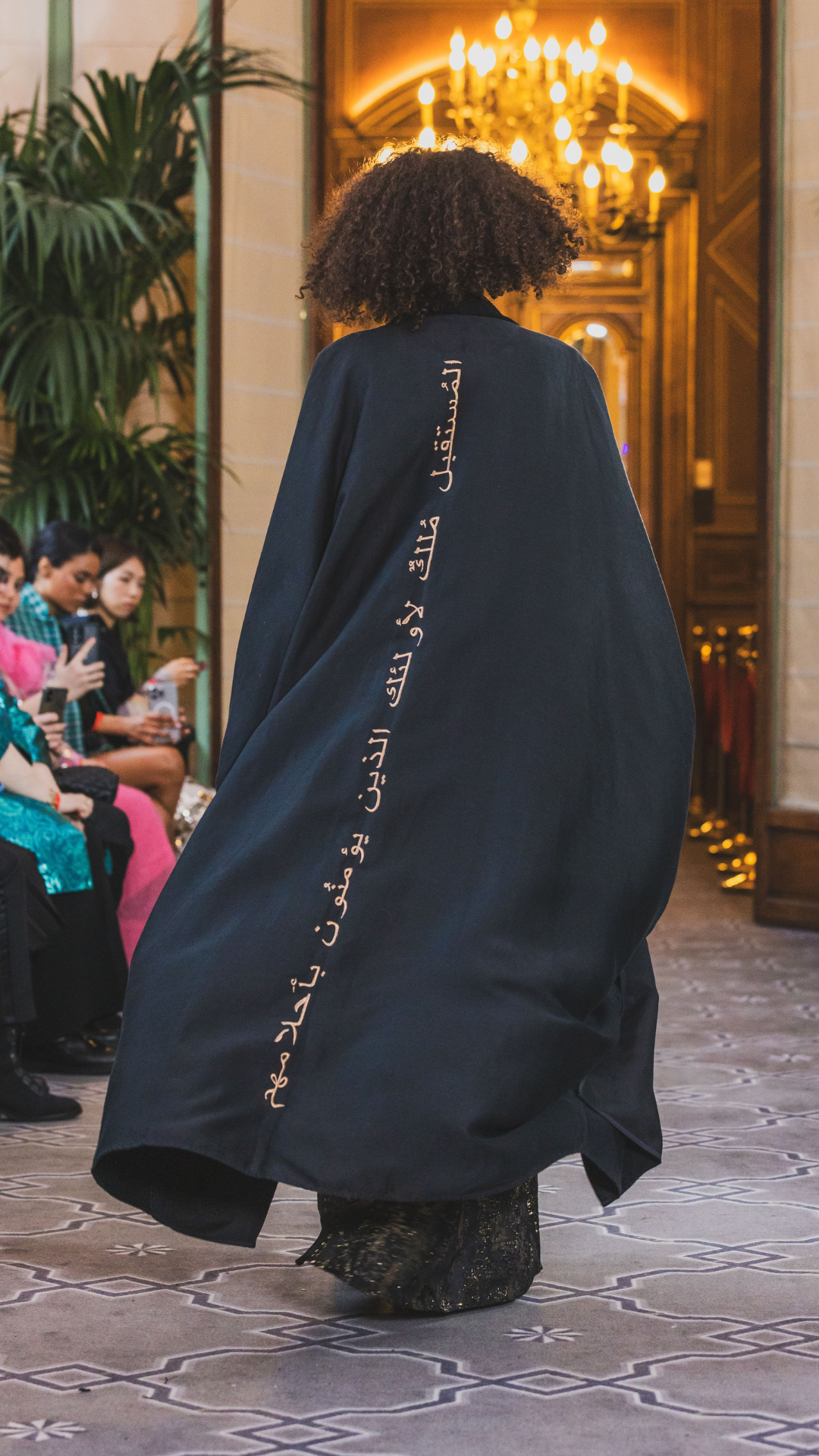 runaway from paris fashion week of abayas, a black abaya   with arabic caligraphy embroidered on the back by omni the label