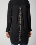 Close-up of the gold-thread Arabic embroidery on the back of Omni The Label’s black shirt – UAE, KSA, Qatar