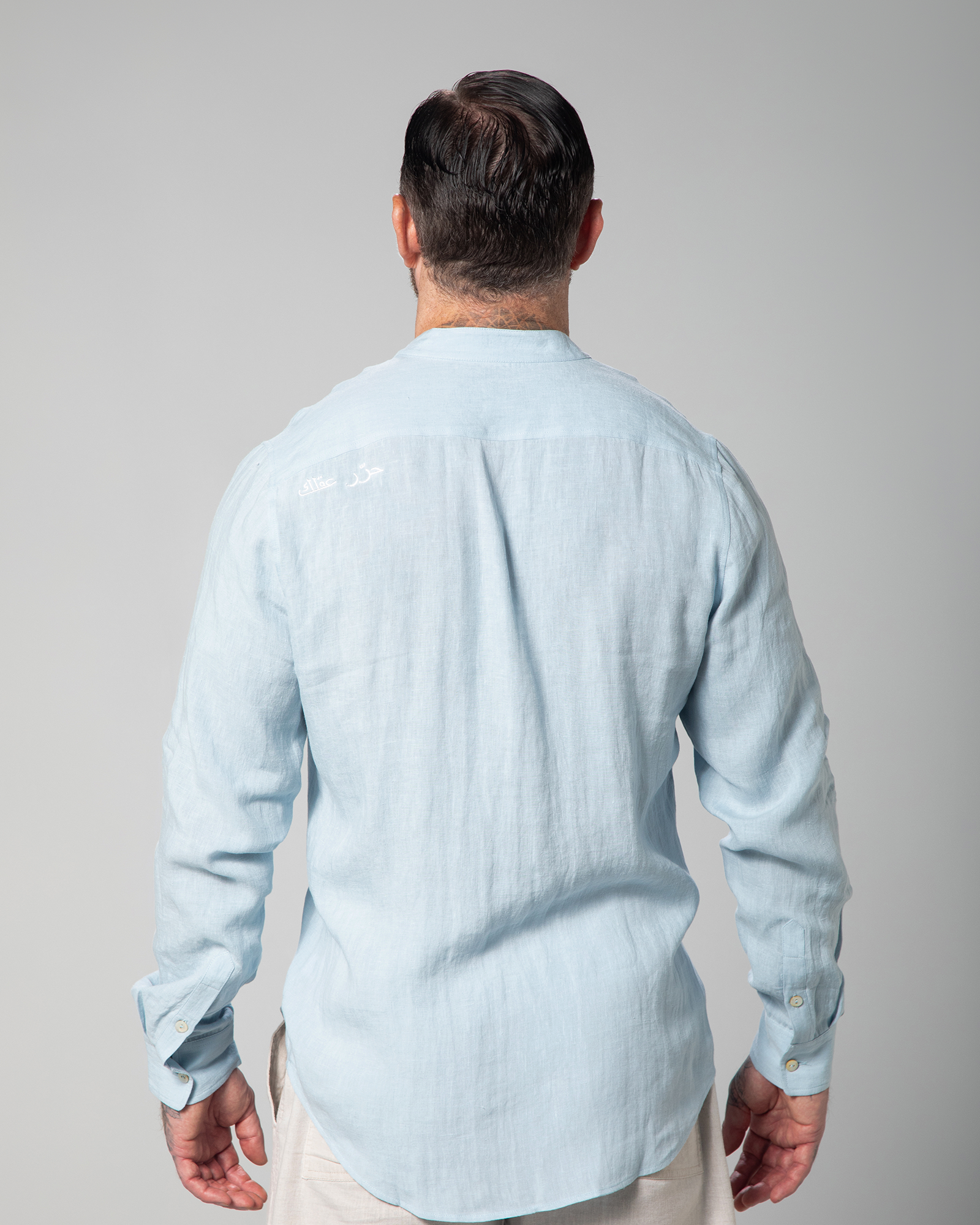 Male model showing the back of light blue St. Tropez linen shirt with Arabic "Free Your Mind" embroidery UAE KSA Qatar