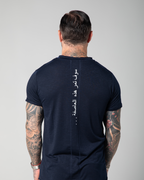 The image shows the back view of a male model wearing a navy blue V-neck t-shirt with white text embroidery on the shoulder UAE KSA Qatar