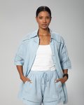 Light blue linen shirt and shorts set for women by Omni The Label, styled on model against neutral studio background UAE KSA Qatar