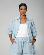 Light blue linen shirt and shorts set for women by Omni The Label, styled on model against neutral studio background UAE KSA Qatar