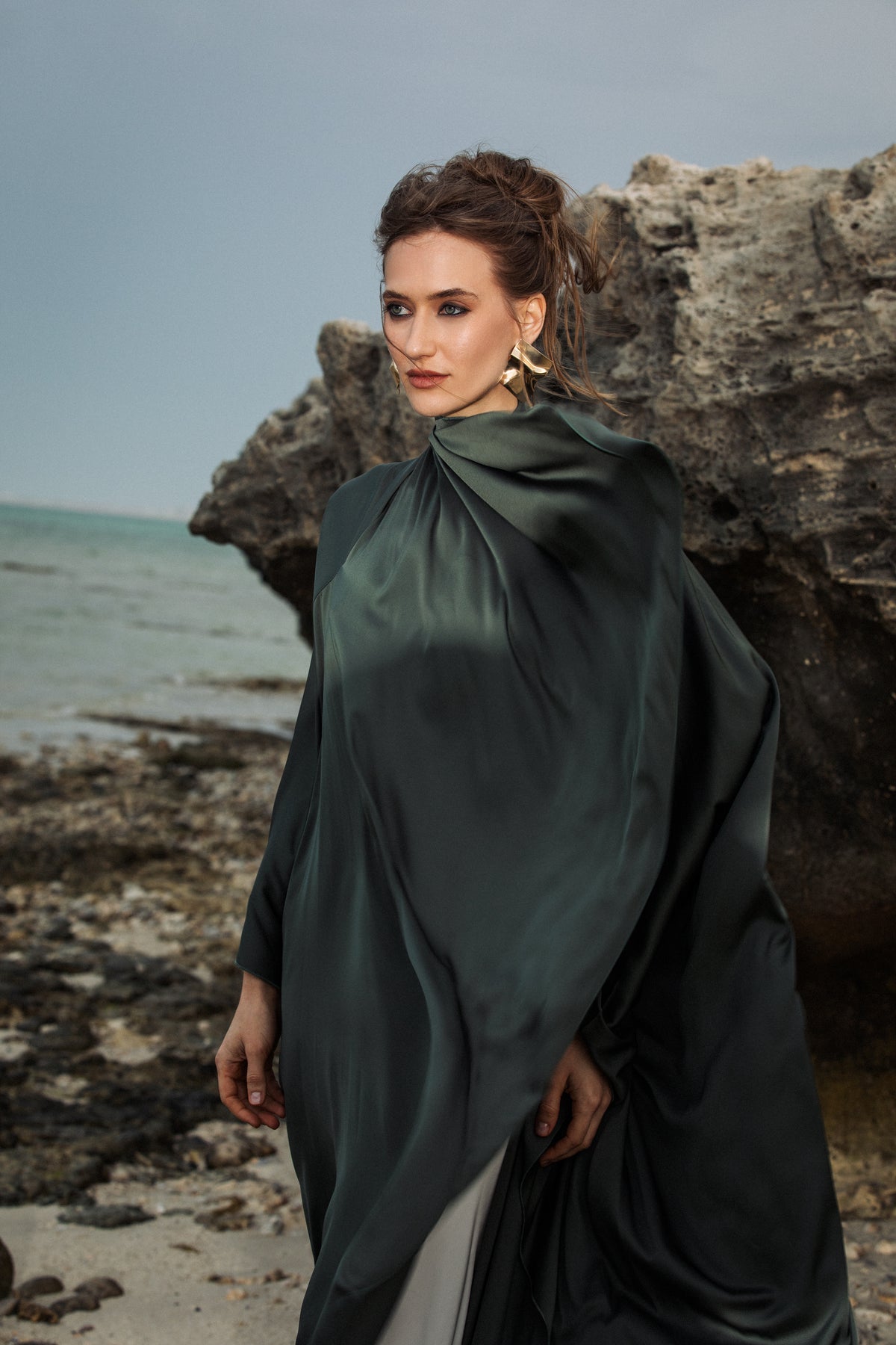 Omni The Label’s Flow Abaya in green worn near stone landscape, styled confidently – UAE, KSA, Qatar
