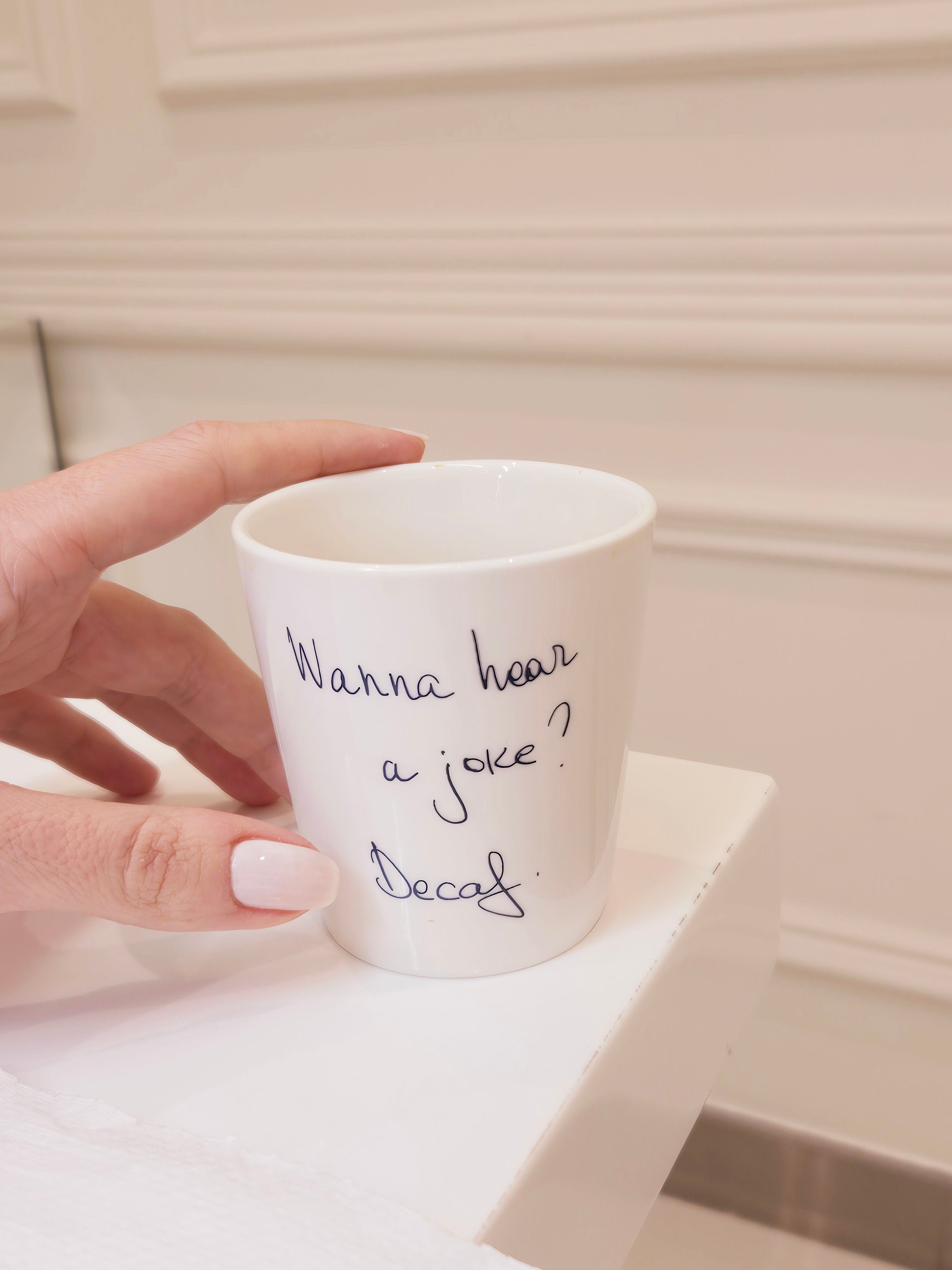A white  coffee cup with the text 'Wanna hear a joke? Decaf' written on it, KSA UAE Qatar