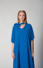 Front view of woman wearing  royal blue dress with statement bow collar and Arabic embroidery on sleeve by Omni The Label modest fashion style for Qatar UAE KSA