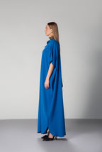 Female model wearing  blue dress with short sleeves and high collar by Omni The Label side profile studio shot ideal for UAE KSA Qatar modest fashion lovers KSA UAE Qatar
