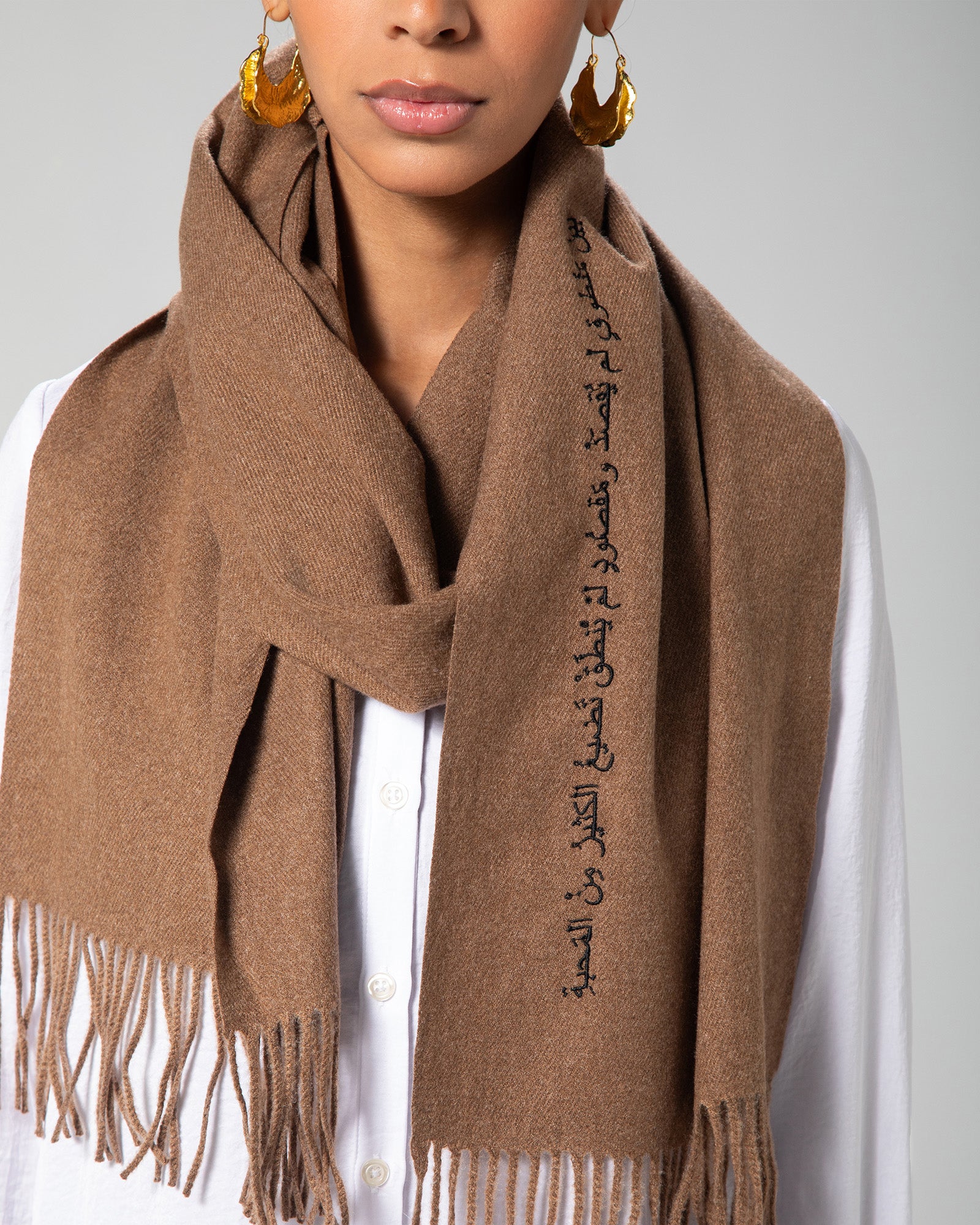 Brown cashmere-look scarf draped stylishly with visible Arabic calligraphy detail – UAE, KSA, Qatar