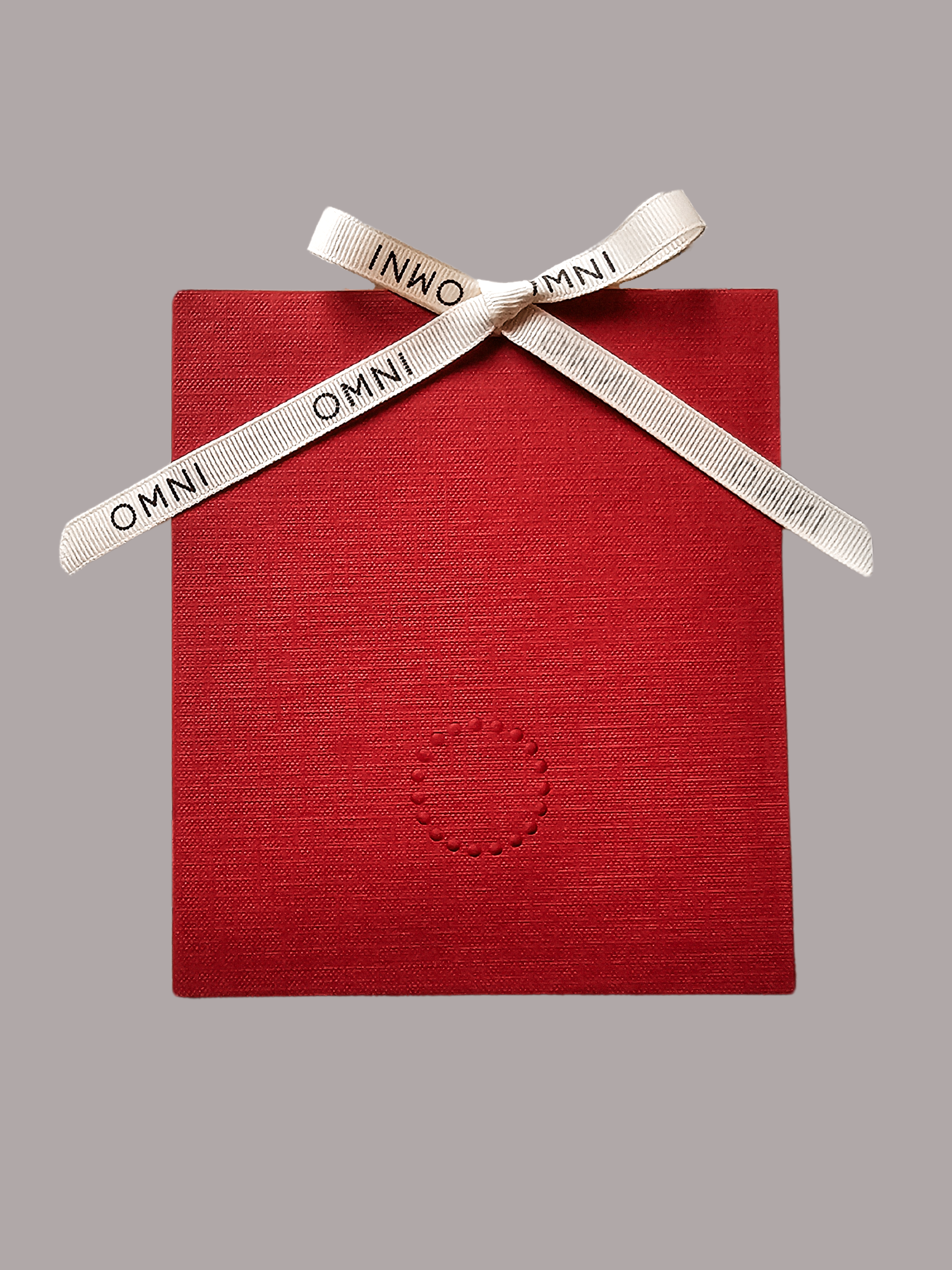 Omni The Label gift card in a red textured envelope tied with a branded ribbon – perfect gifting option available for customers in UAE, KSA, Qatar 