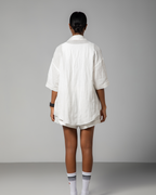 Back view of white linen shirt and shorts set from Omni The Label, showcasing loose tailoring and minimalist silhouette.UAE, KSA, Qatar