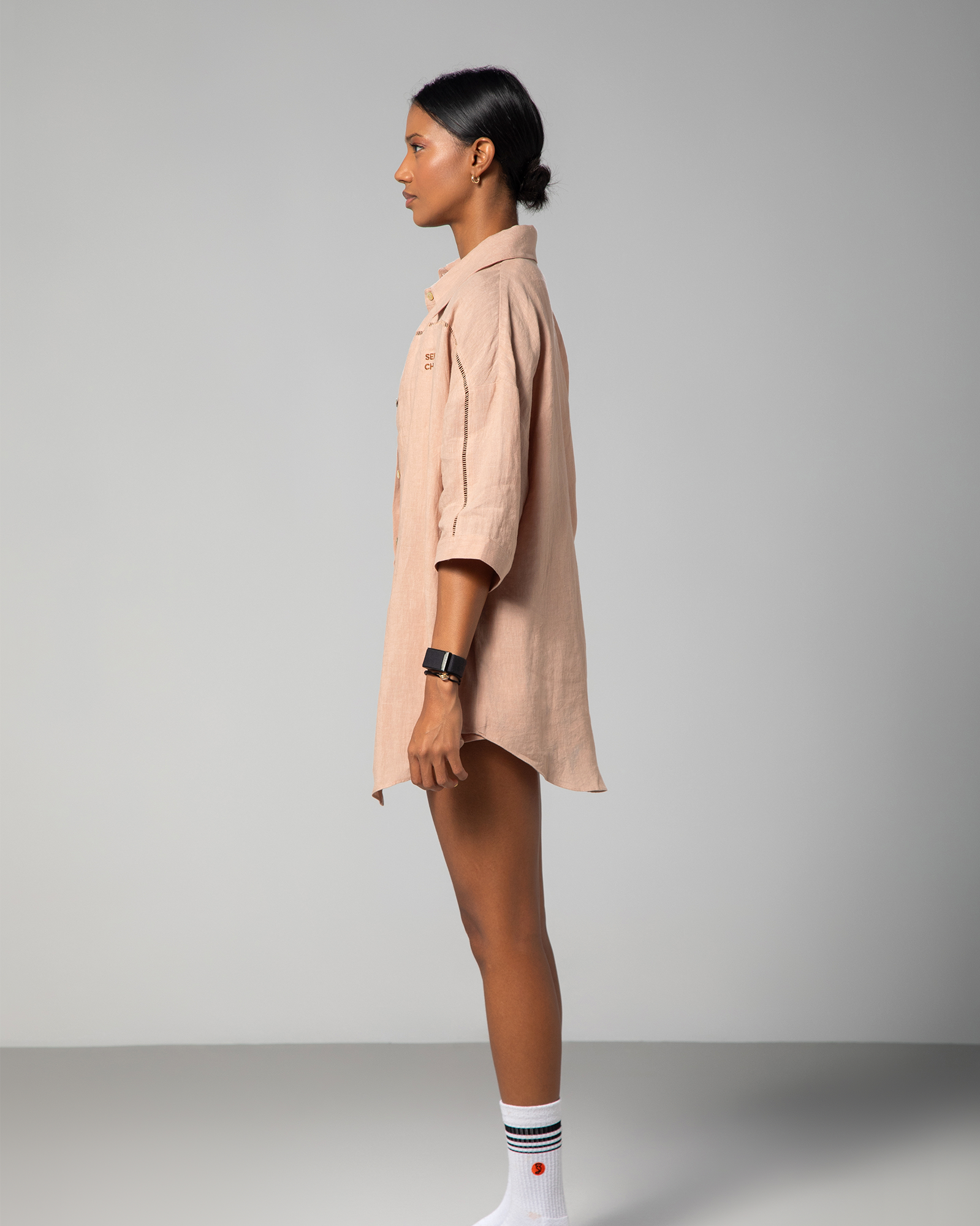 One side view of nude linen shirt and shorts set from Omni The Label, highlighting the loose fit and subtle detailing of the fabric UAE KSA Qatar