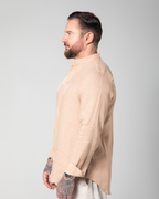 Side view of model wearing the St. Tropez linen shirt in nude, highlighting its lightweight texture Male model walking in the Marbella nude T-shirt by Omni The Label with Arabic embroidery reading this too shall pass shown in motion to highlight soft lightweight slub jersey fabric ideal for UAE KSA Qatar
