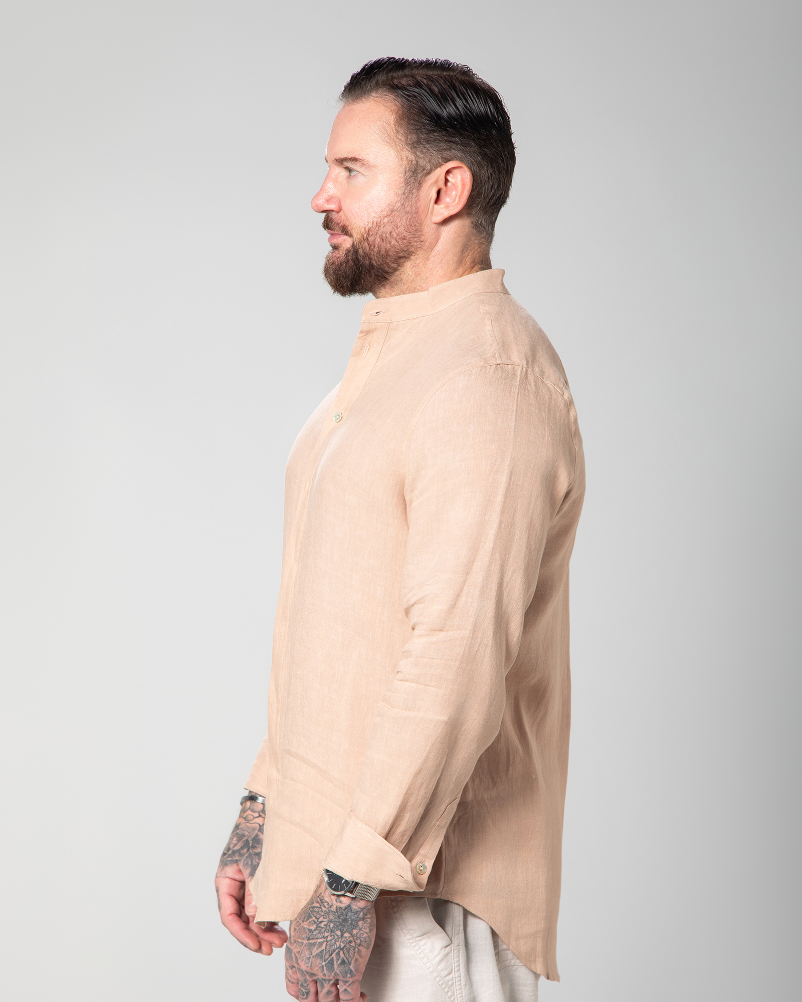 Side view of model wearing the St. Tropez linen shirt in nude, highlighting its lightweight texture Male model walking in the Marbella nude T-shirt by Omni The Label with Arabic embroidery reading this too shall pass shown in motion to highlight soft lightweight slub jersey fabric ideal for UAE KSA Qatar
