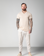 Male model wearing the Marbella nude V-neck T-shirt by Omni The Label, crafted from 100% slub jersey for a breathable, lightweight feel. UAE KSA Qatar