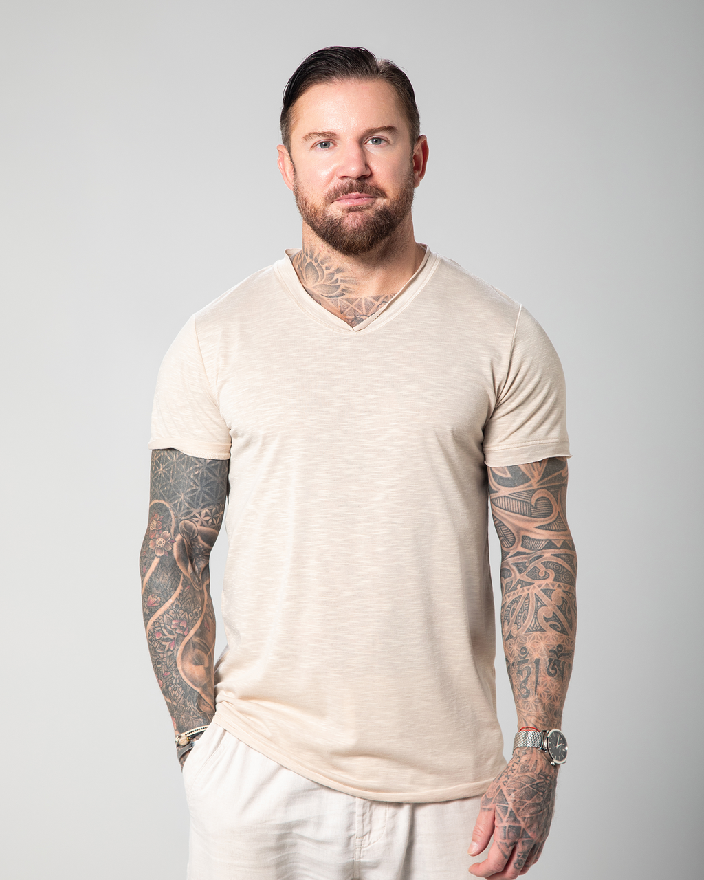 The image depicts the front view of a male model wearing a nude-colored Marbella V-neck T-shirt. The T-shirt is designed with a slub jersey texture, enhancing its breathability and comfort UAE KSA Qatar