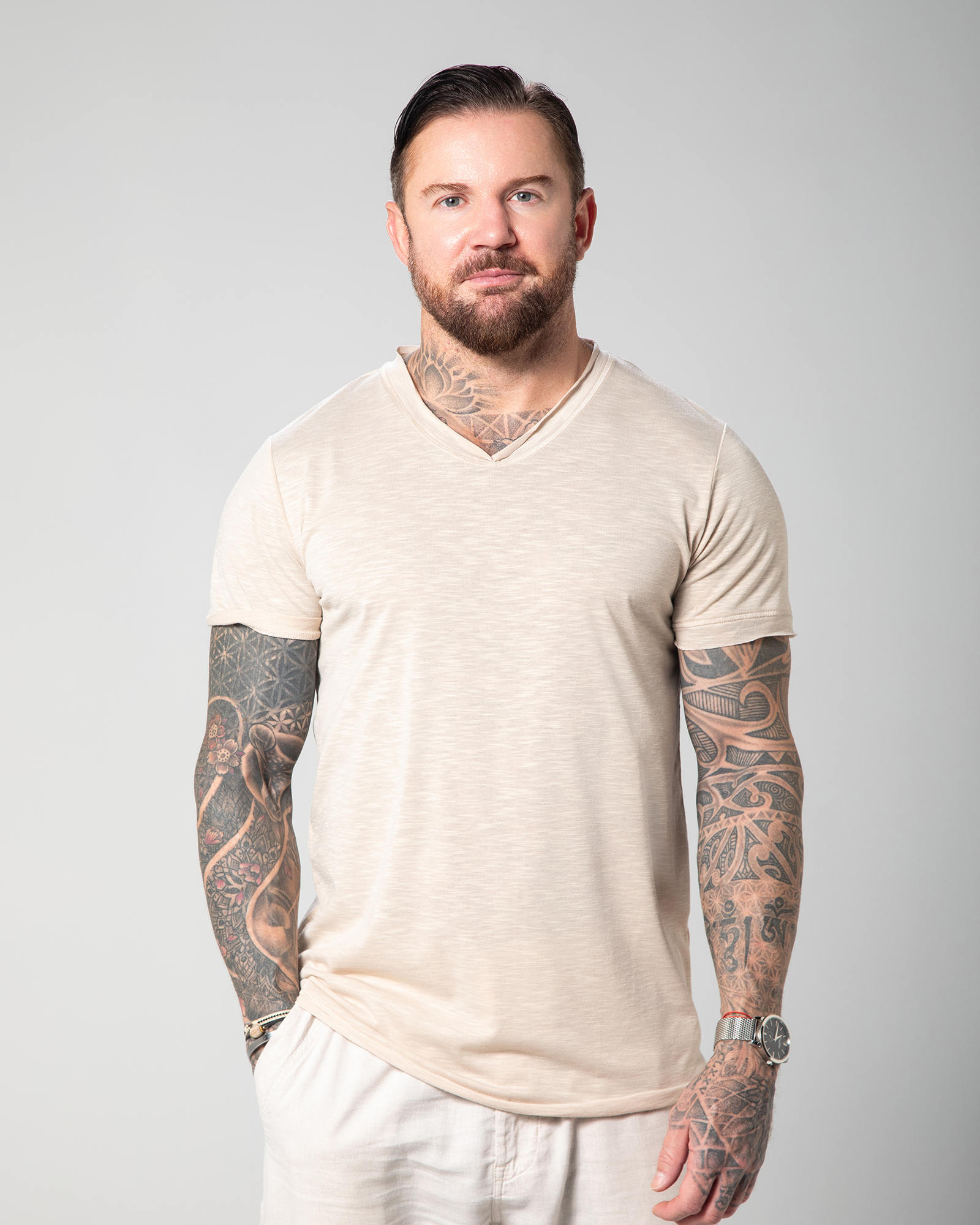 The image depicts the front view of a male model wearing a nude-colored Marbella V-neck T-shirt. The T-shirt is designed with a slub jersey texture, enhancing its breathability and comfort UAE KSA Qatar